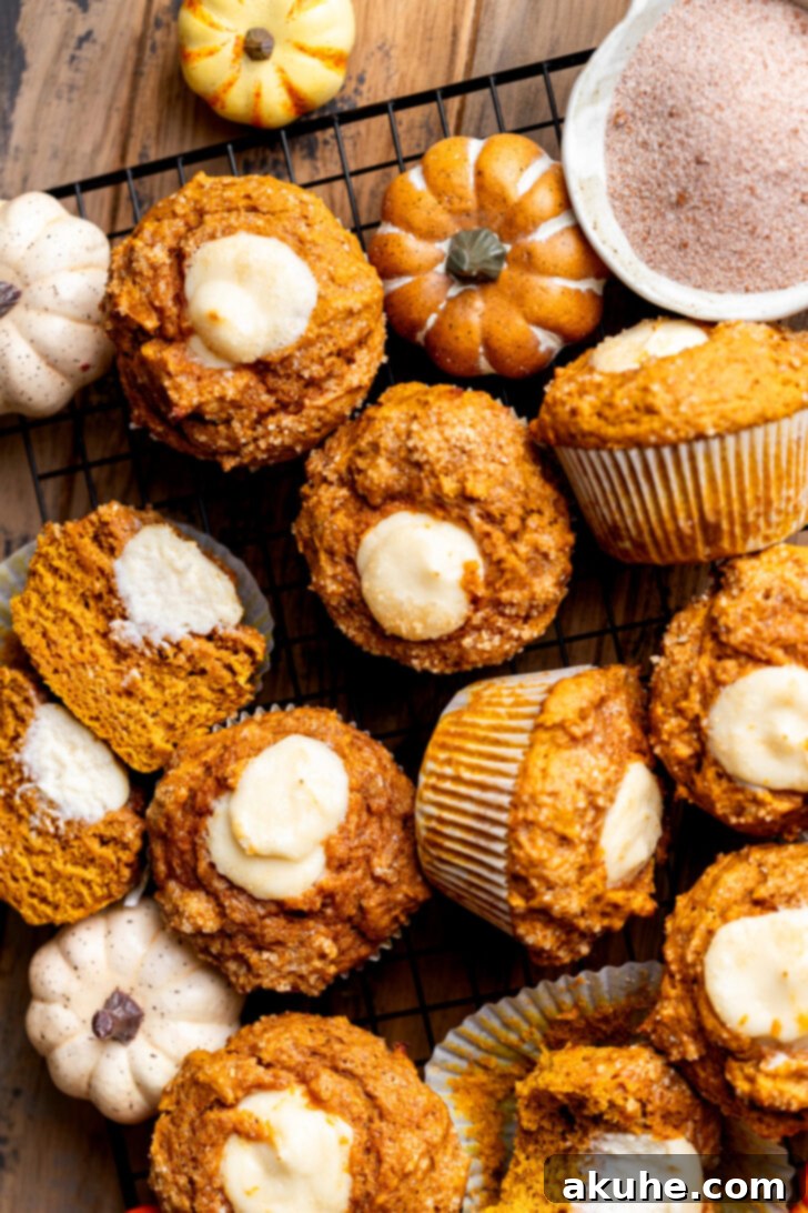 Overhead shot of a batch of freshly baked Pumpkin Cream Cheese Muffins cooling on a wire rack.