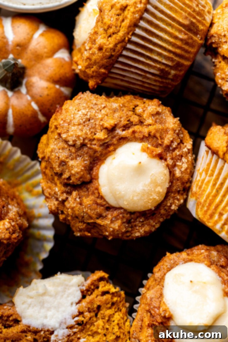 Close-up of baked pumpkin cream cheese muffins, showing the textured tops and rich color.
