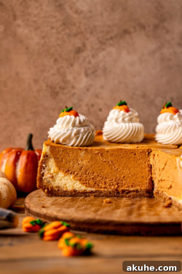 Side view of a tall, multi-layered pumpkin cheesecake with whipped cream.