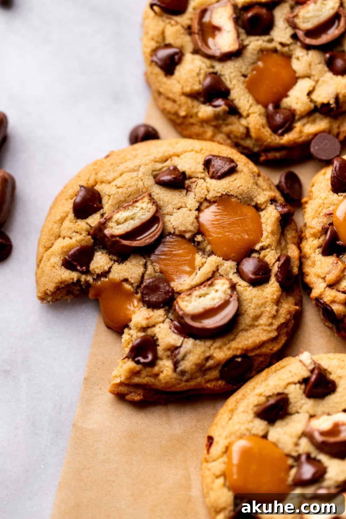 A delicious Twix cookie with a bite missing, showing off the perfectly chewy texture and delicious fillings.