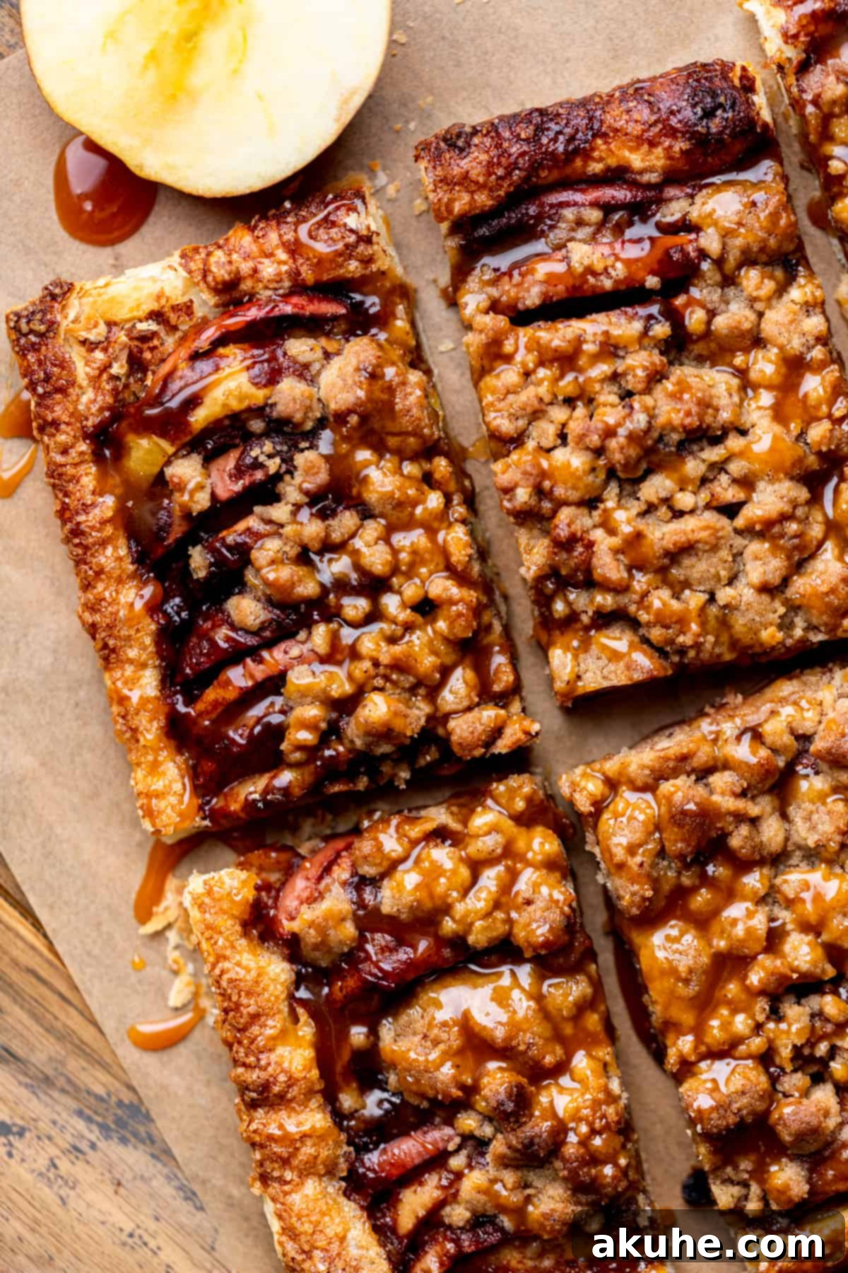 Golden Apple Puff Tart 2 Top view of a beautifully golden-brown puff pastry apple tart, garnished with caramel drizzle and a streusel topping, ready to be served.