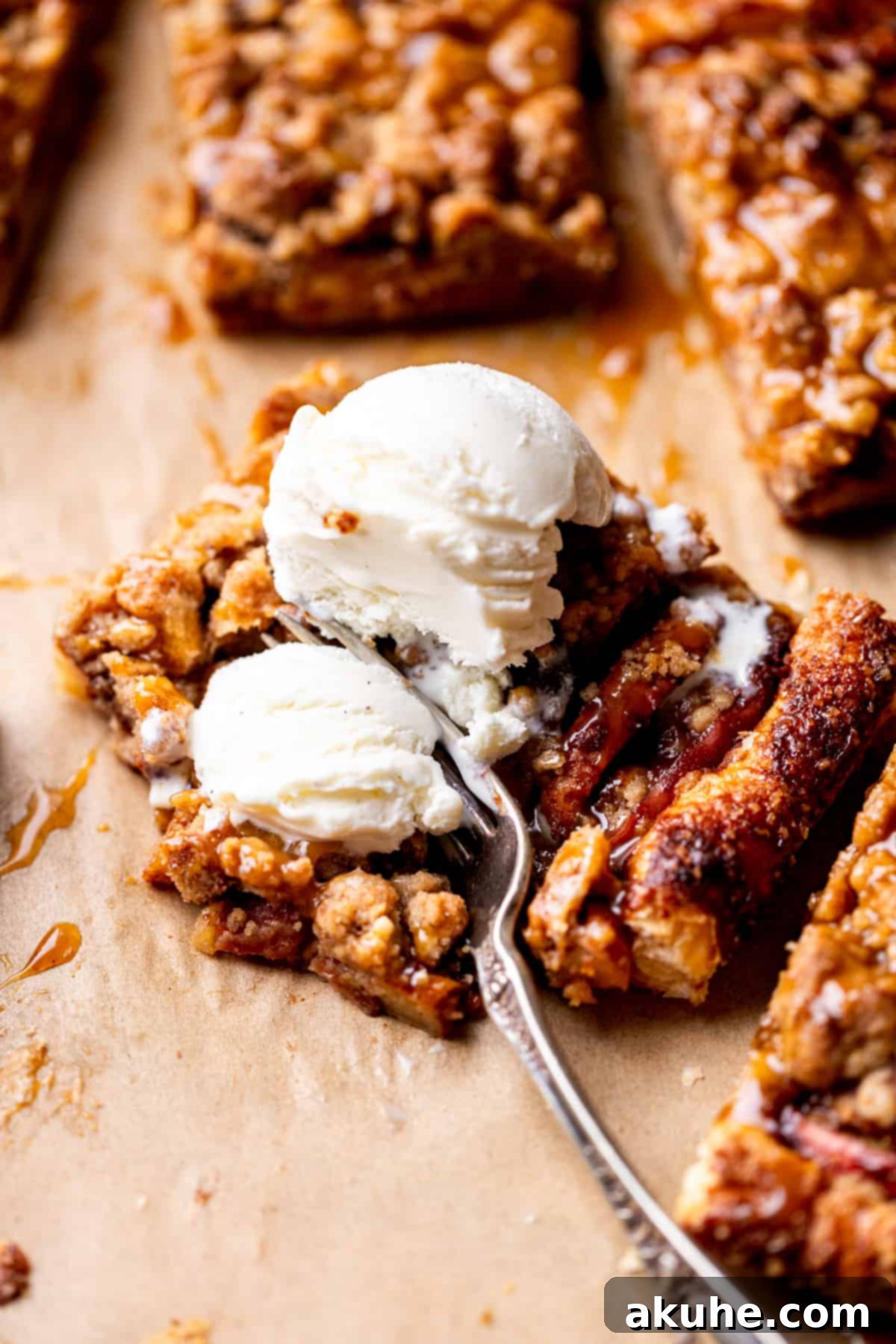 Golden Apple Puff Tart 3 A slice of puff pastry apple tart topped with a scoop of vanilla ice cream, showing the flaky crust and caramelized apple filling.