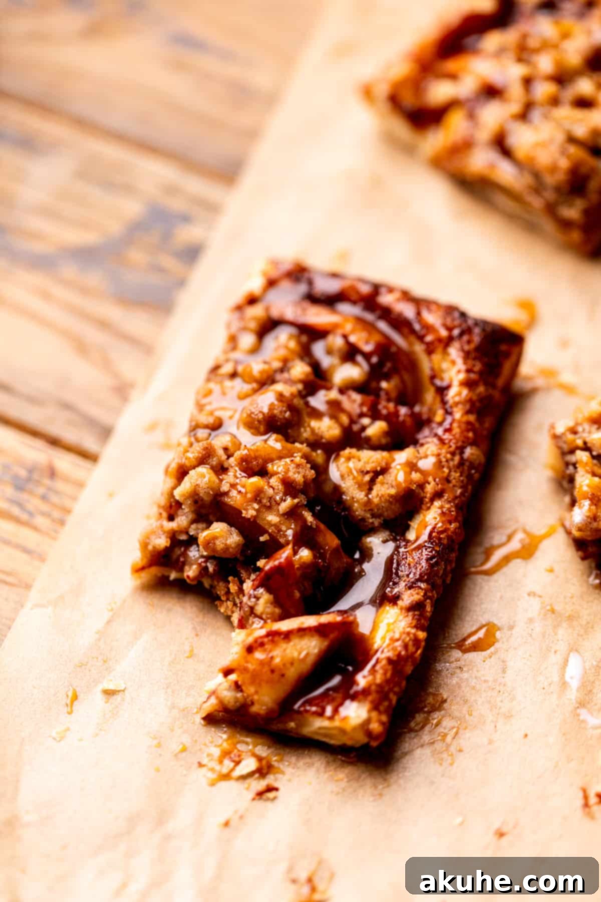 Golden Apple Puff Tart 10 A puff pastry apple tart with a bite taken out, showing the rich apple filling and crunchy streusel.