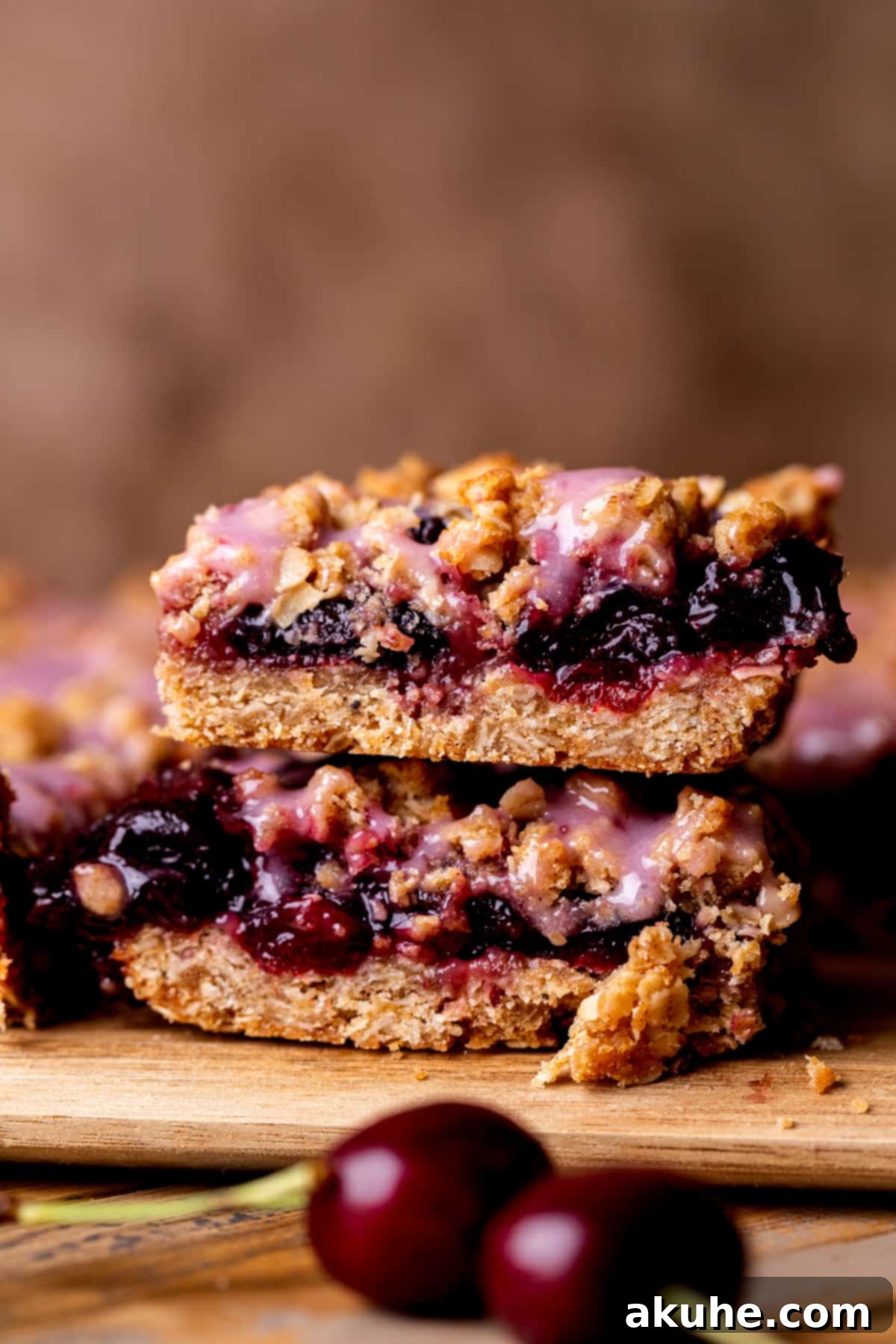 Classic Cherry Pie Bars 2 Stack of two golden-brown cherry pie bars with a vibrant cherry filling and a delicate white glaze drizzle.