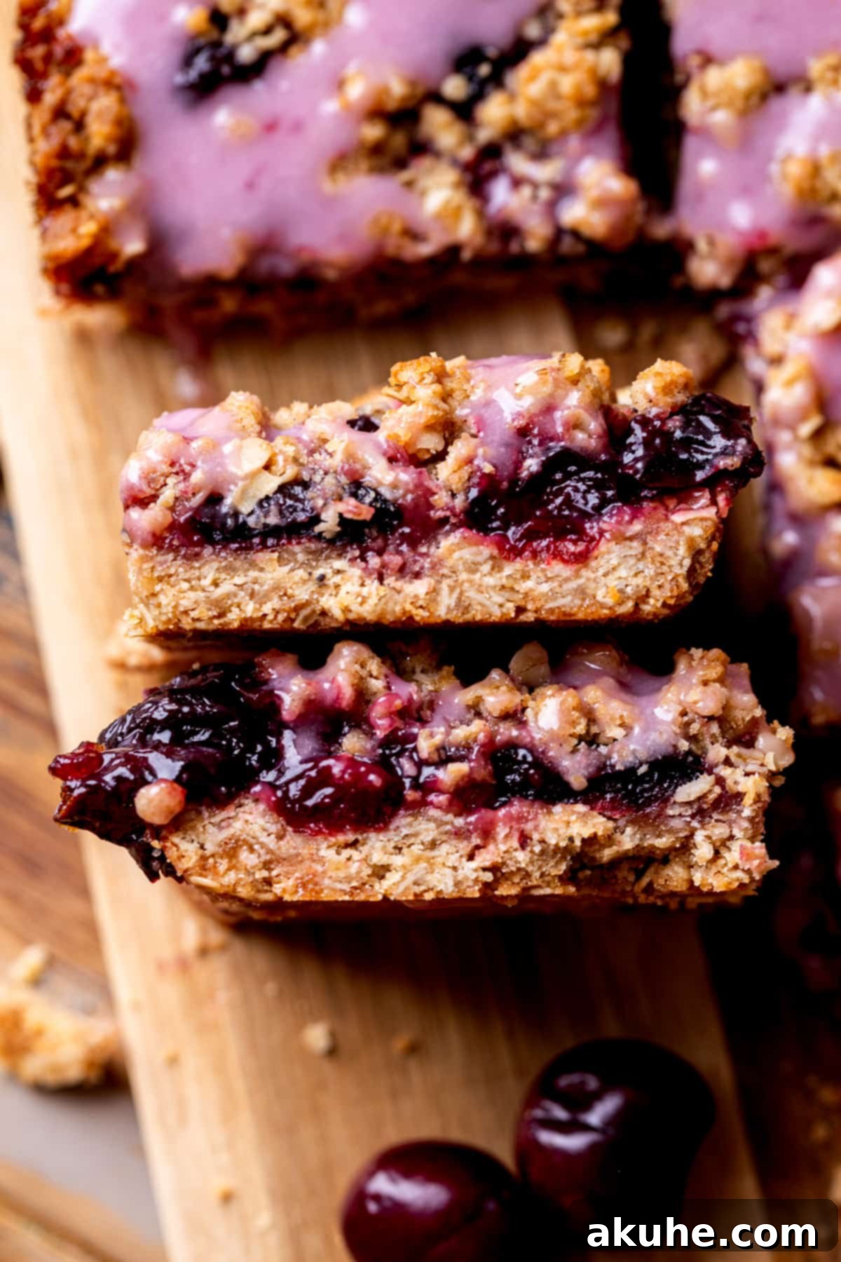 Classic Cherry Pie Bars 9 Two freshly cut cherry pie bars, showing the layered structure with a bite taken out of one, revealing the rich cherry filling.
