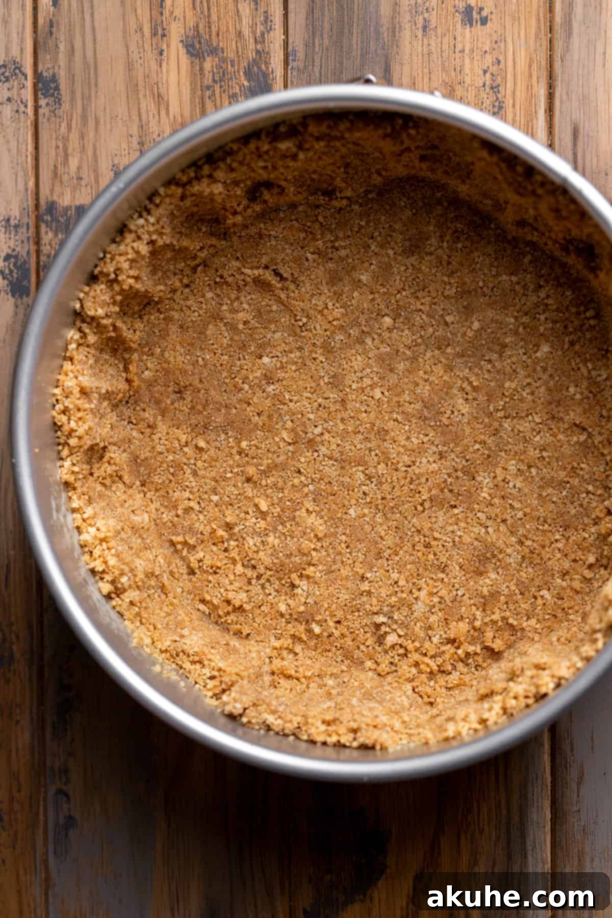 Spiced Apple Cider Cheesecake 4 Graham cracker crust in a pan.