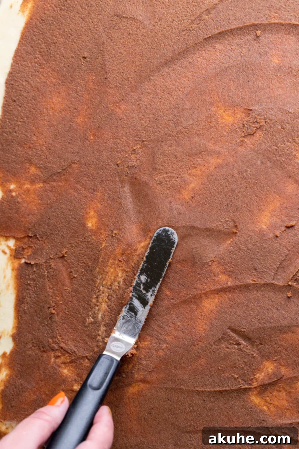 Irresistible Caramel Buns 8 Spreading cinnamon filling over the dough.
