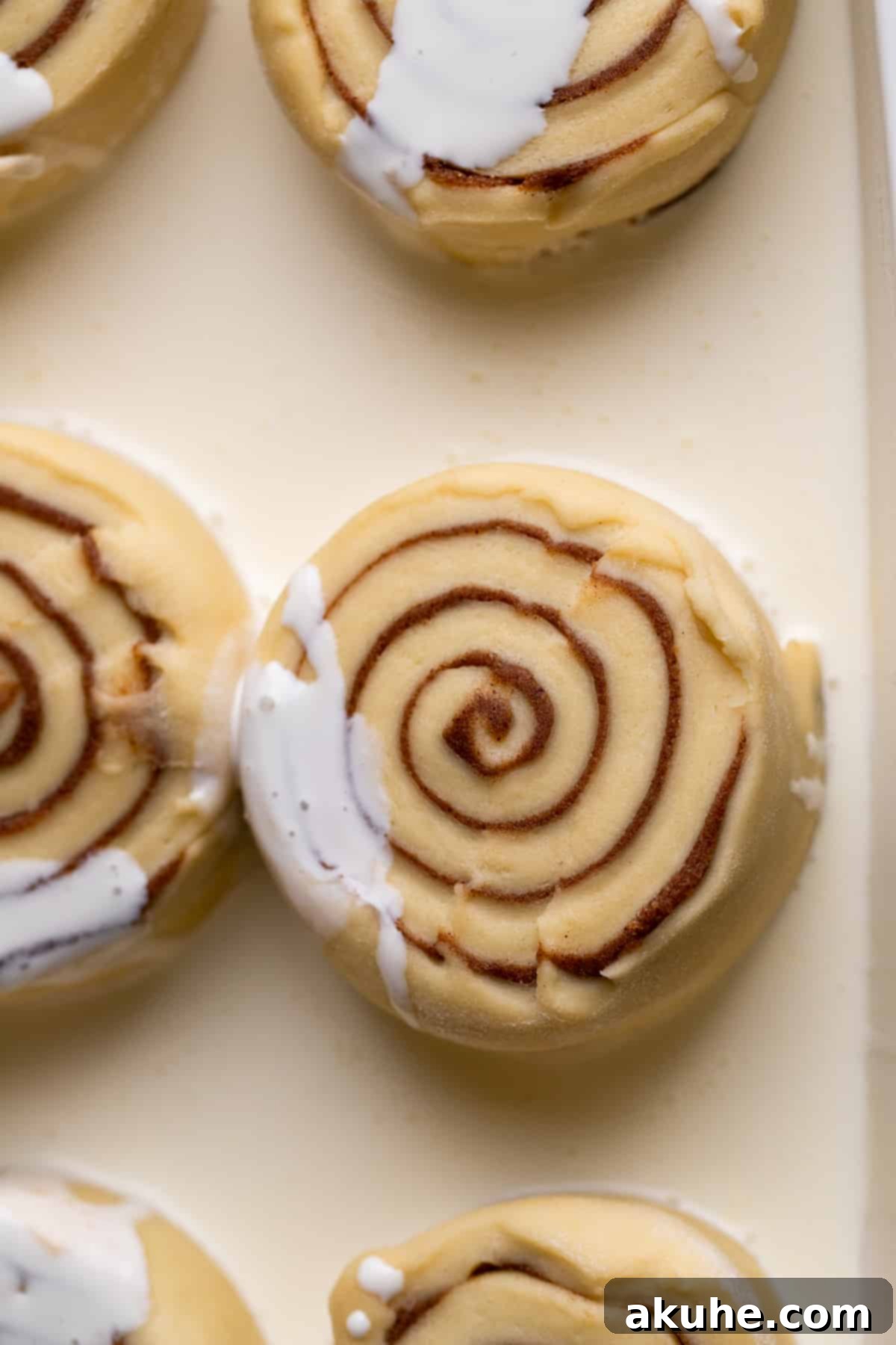 Spiced Apple Cider Cinnamon Rolls 6 Unbaked apple cider cinnamon rolls sitting in a baking pan, generously bathed in heavy cream, ready for the oven.