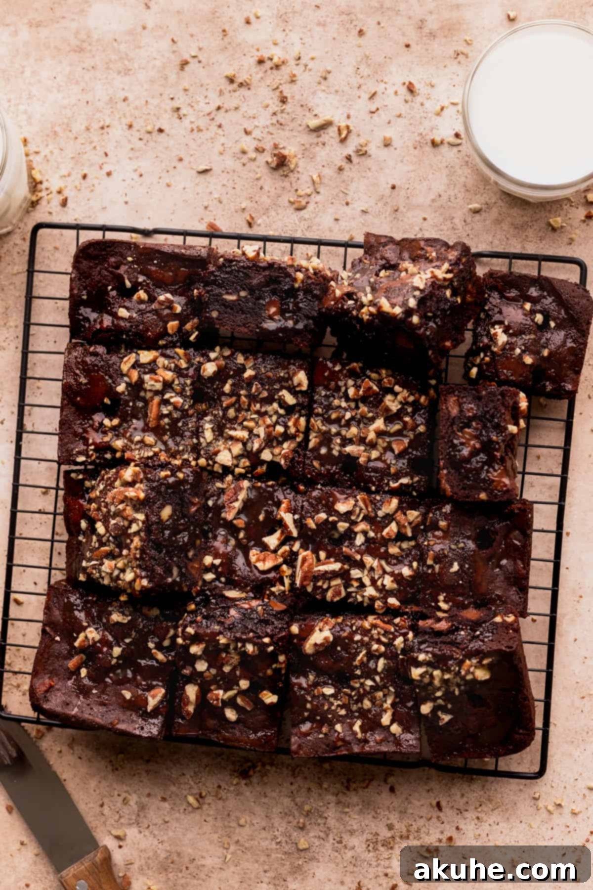 Pecan Caramel Fudge Brownies 11 Cleanly cut turtle brownies arranged on a wire rack, showcasing their layers.
