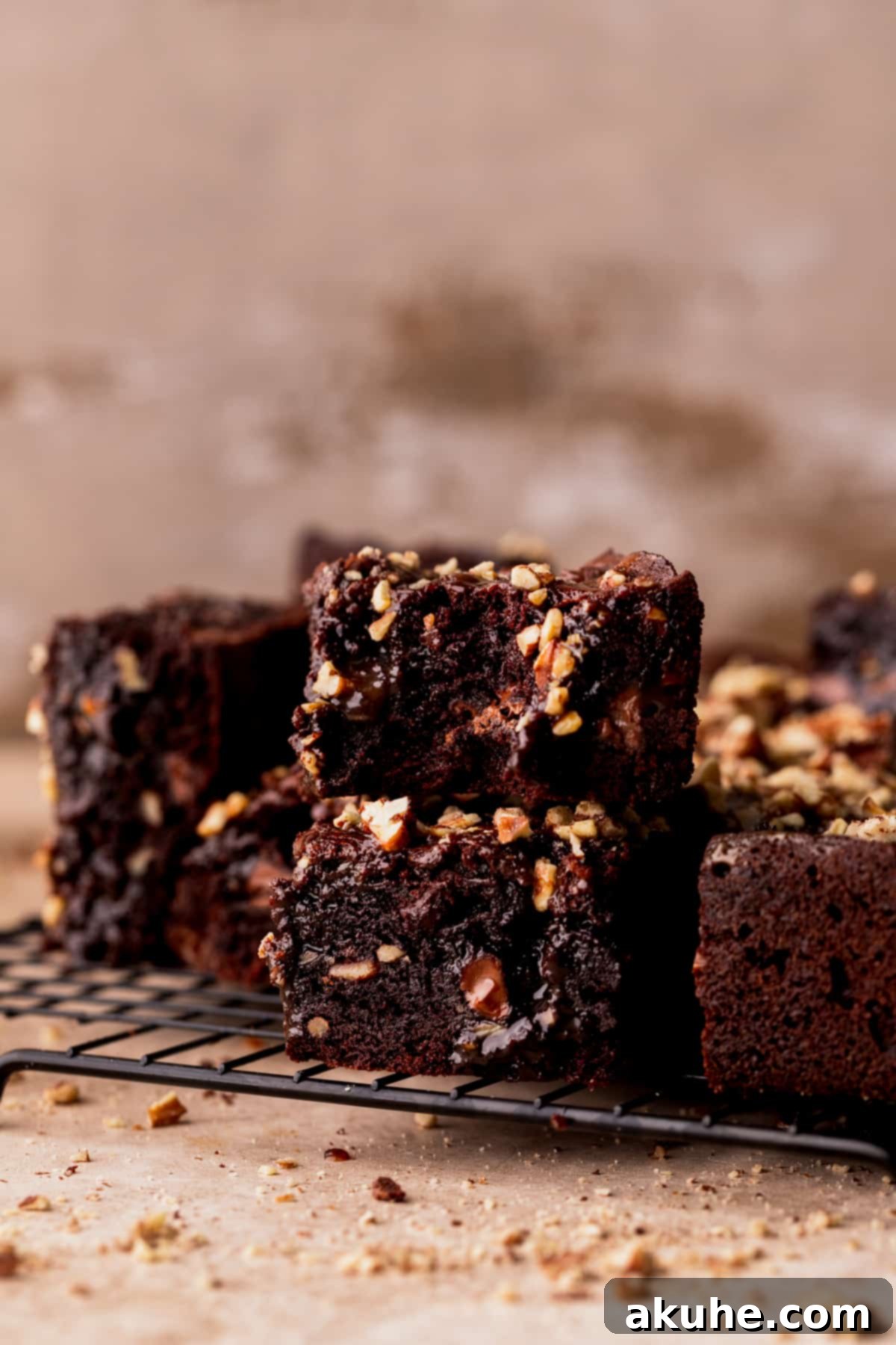 Pecan Caramel Fudge Brownies 12 A stack of two perfectly cut turtle brownies, showing their rich chocolate, caramel, and pecan layers.