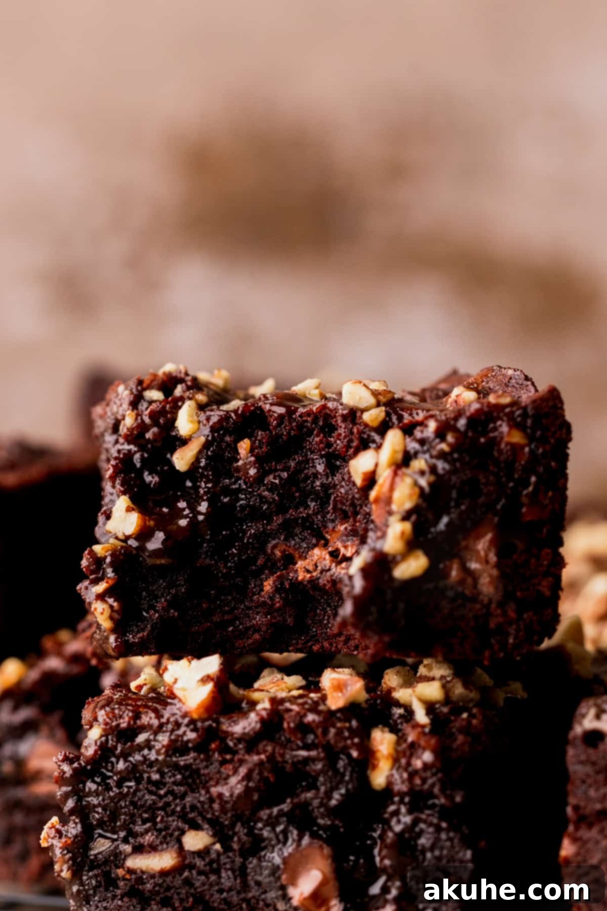 Pecan Caramel Fudge Brownies 3 A fudgy brownie with a bite taken out, revealing the caramel and pecans inside.