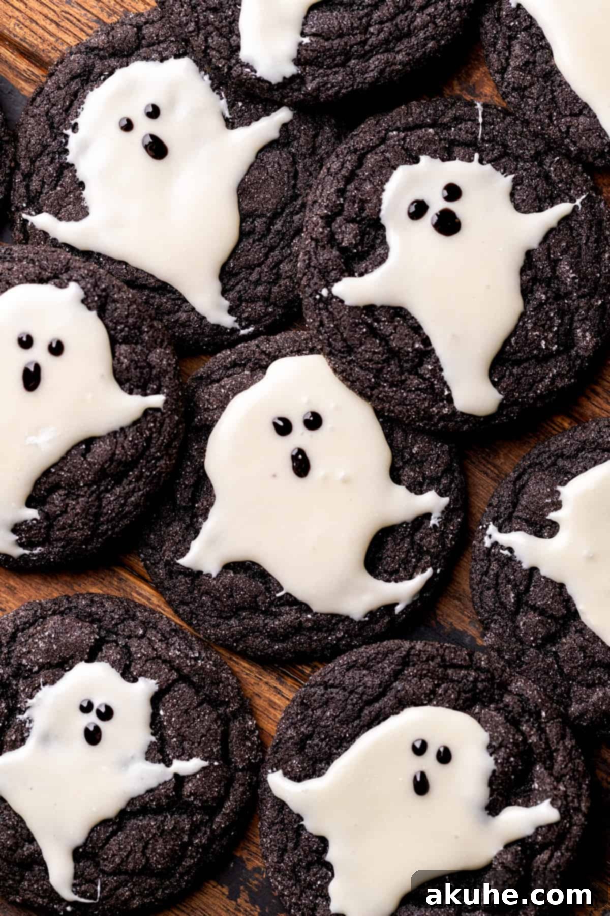 A cluster of freshly baked black cocoa ghost cookies, gently touching, displaying their perfect round shape and sugar coating before decoration.