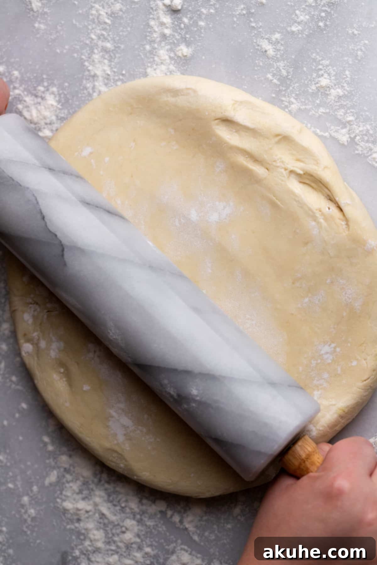 Rolling out the cinnamon roll dough on a floured surface.