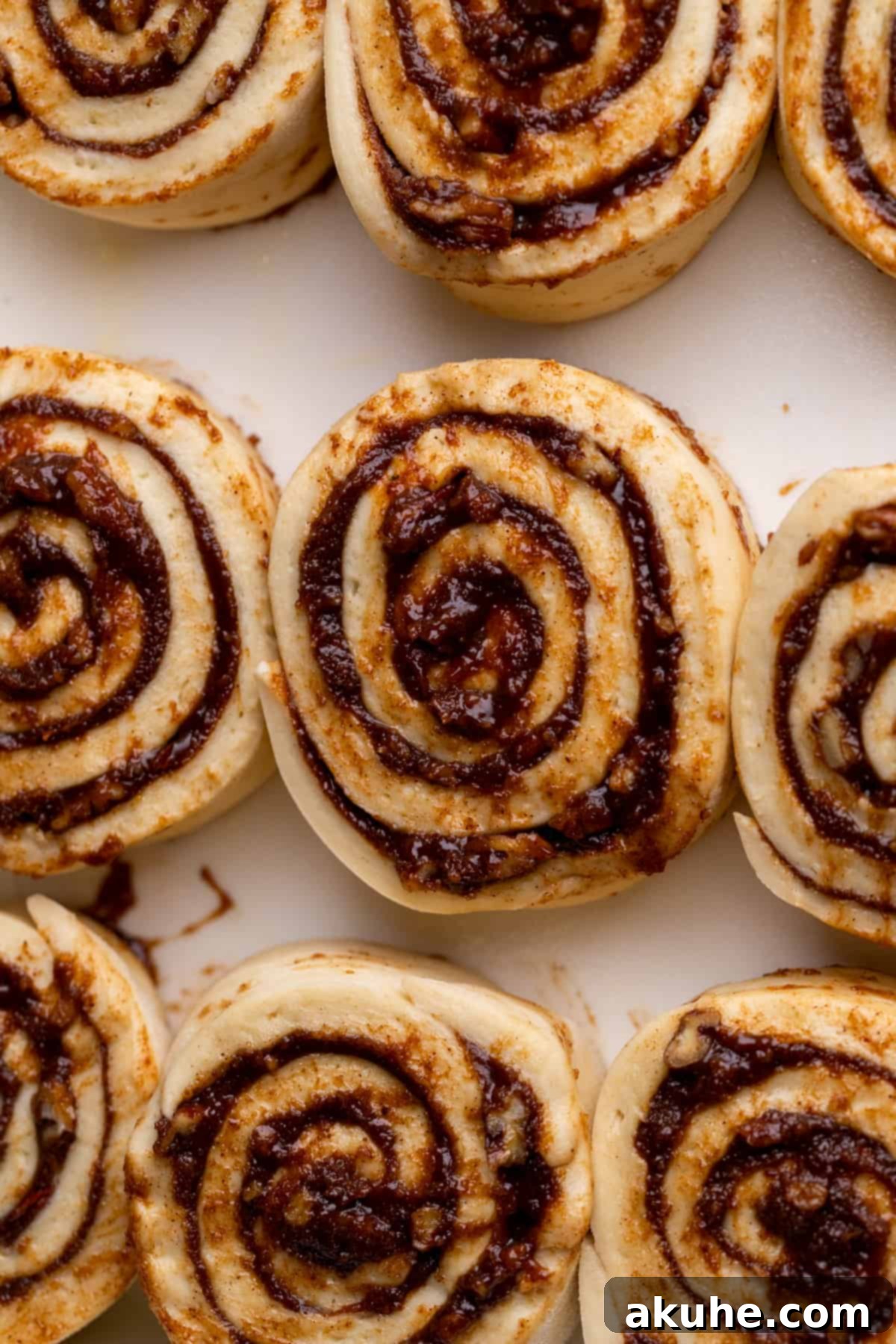 Raw cinnamon rolls arranged in a baking pan, ready for their second rise.