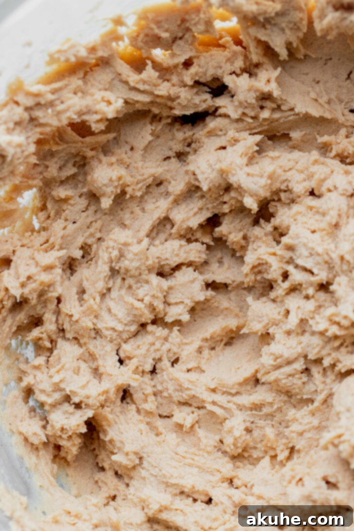 Whipped peanut butter and cream cheese in a mixing bowl, looking smooth and creamy.
