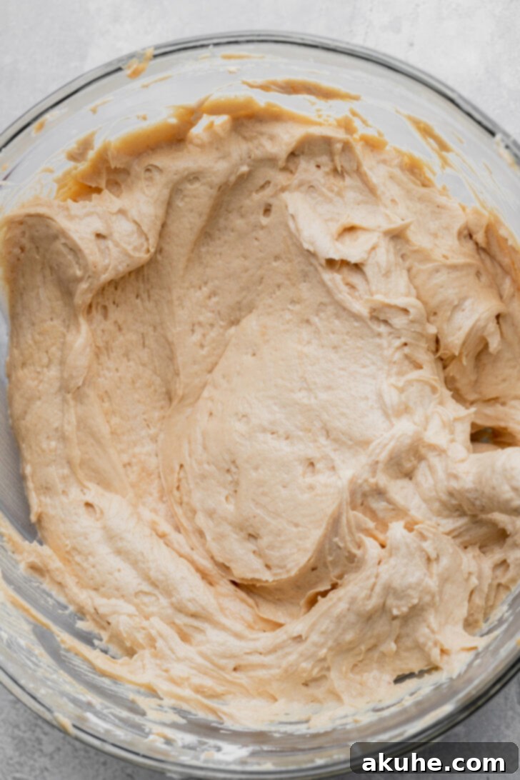 Half of the creamy peanut butter batter spread evenly over the Oreo crust in a pie pan.