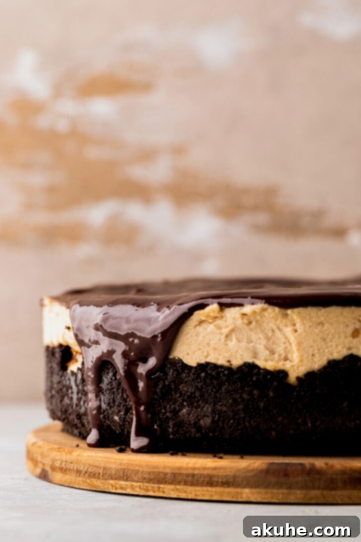 Smooth, glossy chocolate ganache being spread over the chilled peanut butter pie, dripping slightly over the edges.