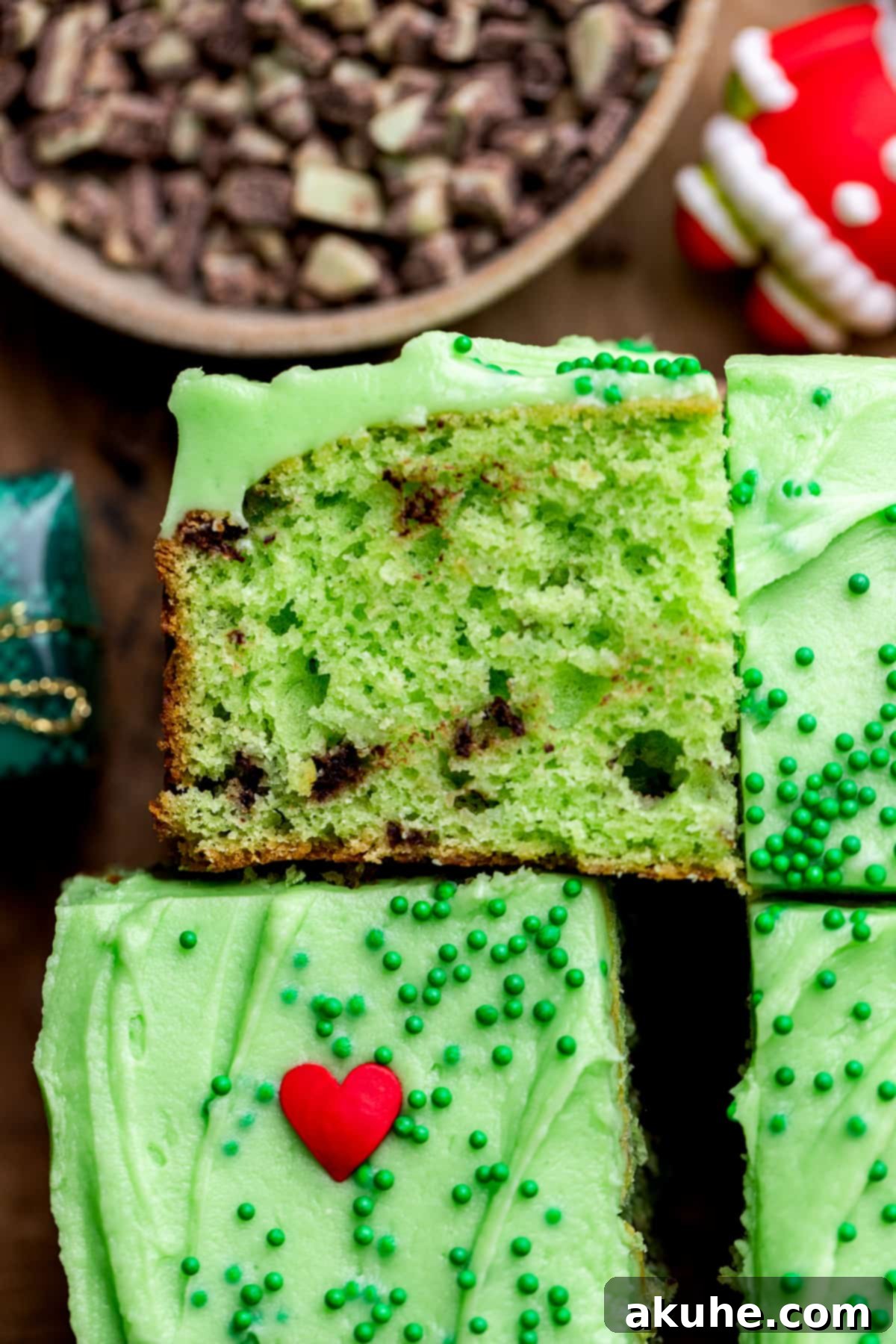 Grinchy Holiday Cake 7 A single slice of vibrant green Grinch cake, showing the moist interior with Andes mint pieces and a perfect layer of green frosting.