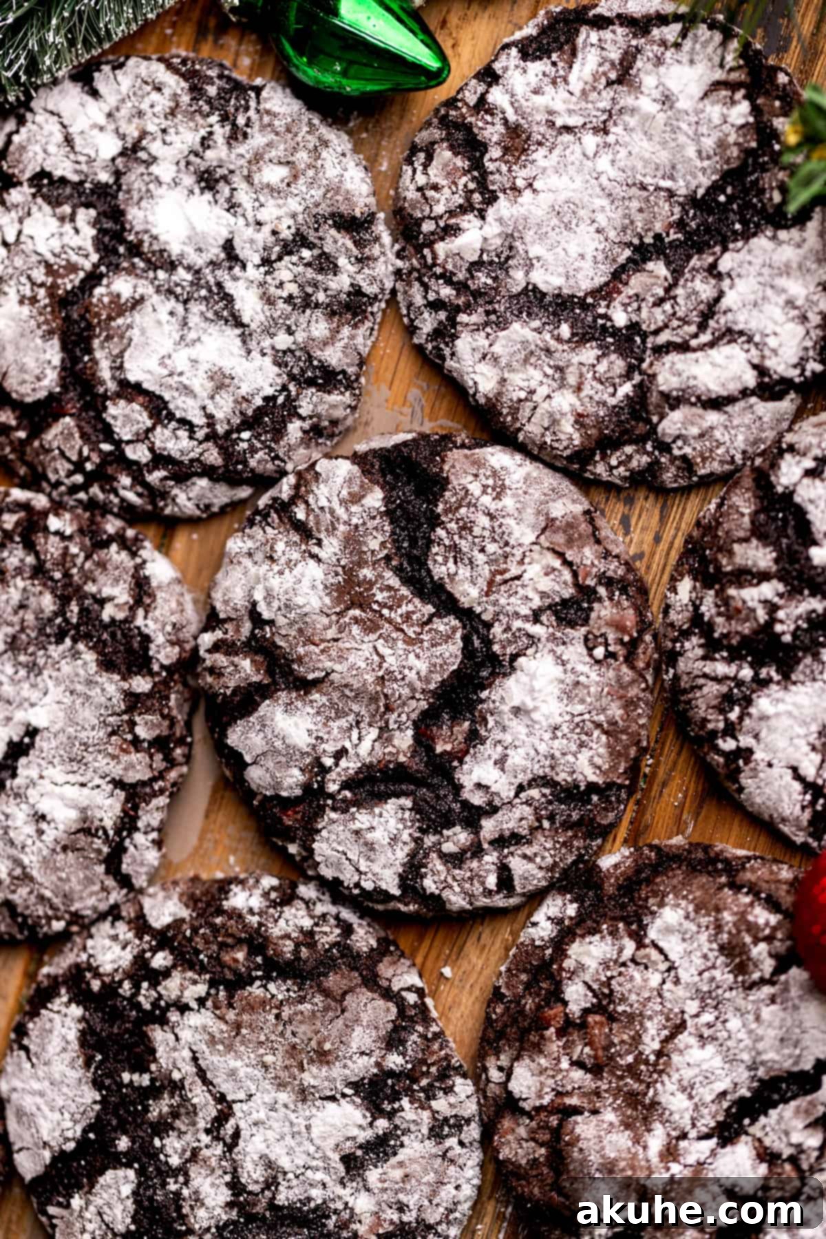 A close-up top view of freshly baked chocolate crinkle cookies cooling on a wire rack.