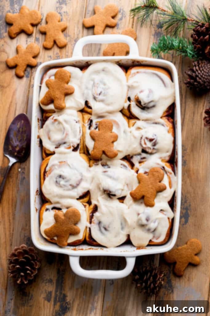 Festive gingerbread cinnamon rolls baked in a pan, charmingly garnished with small gingerbread men cookies.