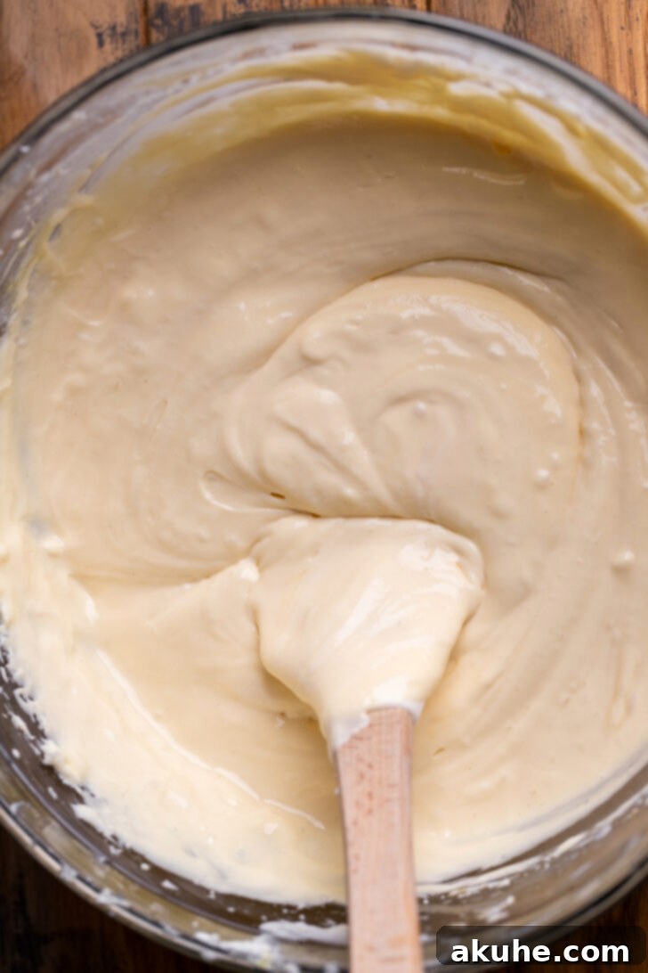 Spiced Caramel Apple Cheesecake Bars 6 Smooth and creamy cheesecake batter in a mixing bowl.