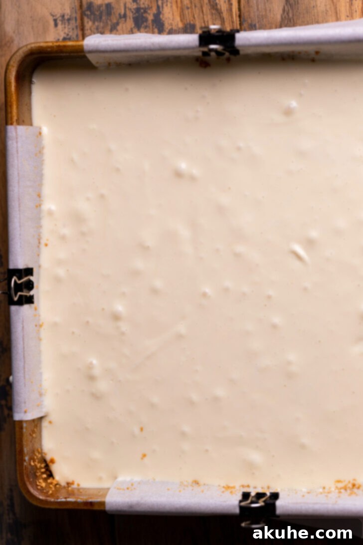 Spiced Caramel Apple Cheesecake Bars 7 Cheesecake batter poured over the pre-baked graham cracker crust in the pan.