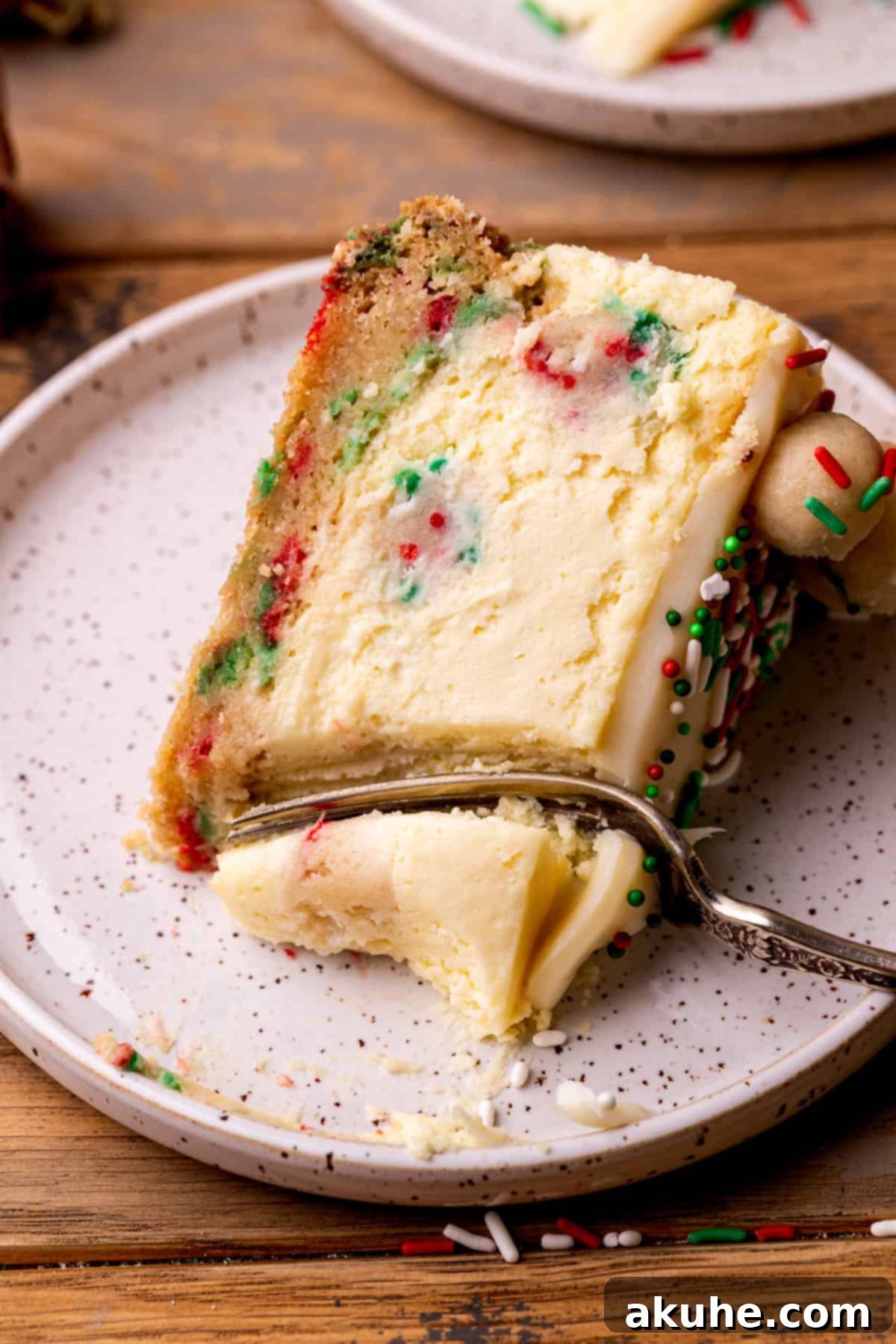 Sugar Cookie Dream Cheesecake 2 A delectable slice of sugar cookie cheesecake, showcasing its rich layers and edible cookie dough filling, with a fork poised for a bite.