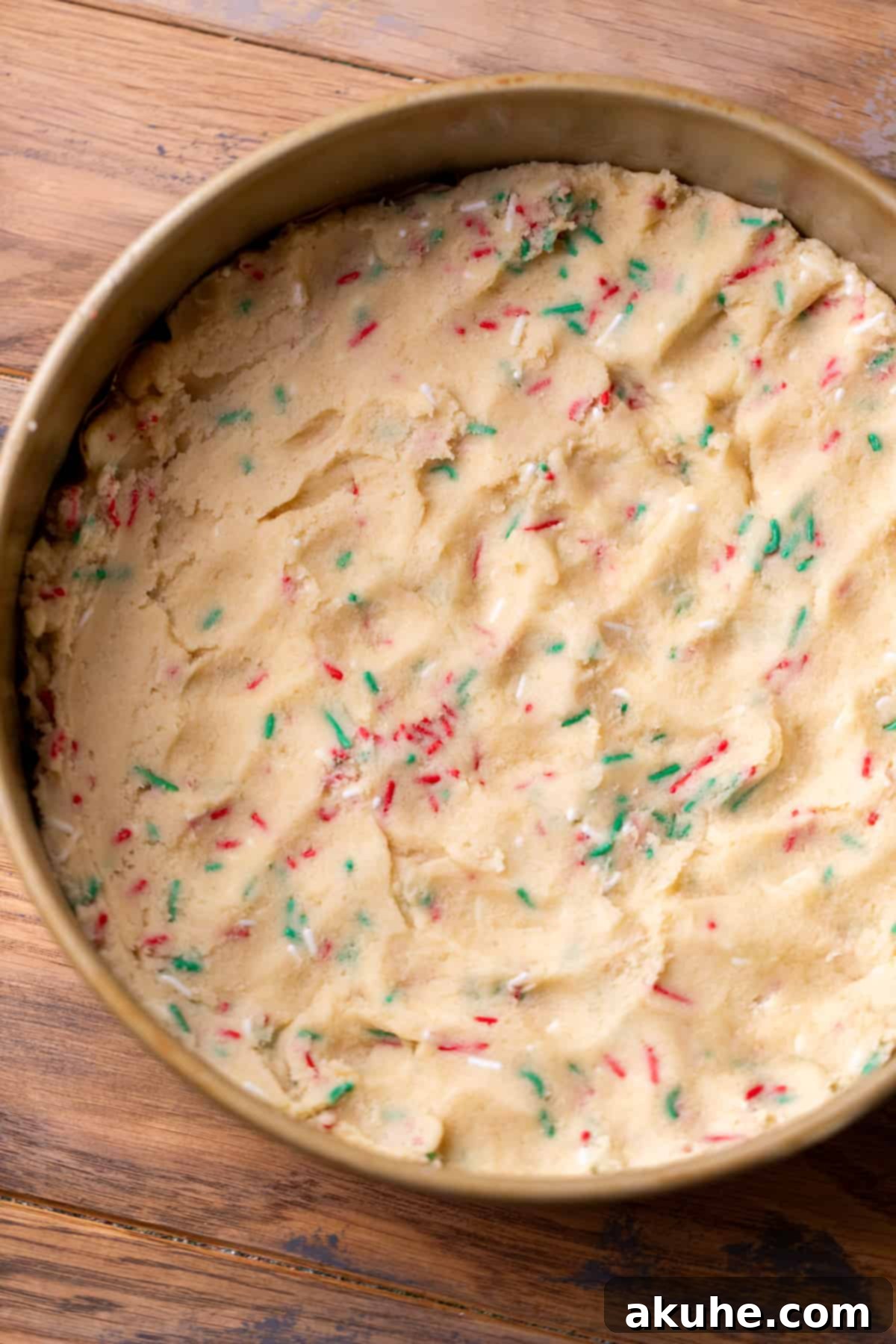 Sugar Cookie Dream Cheesecake 5 Sugar cookie dough evenly pressed into the bottom of a springform pan, forming the crust.