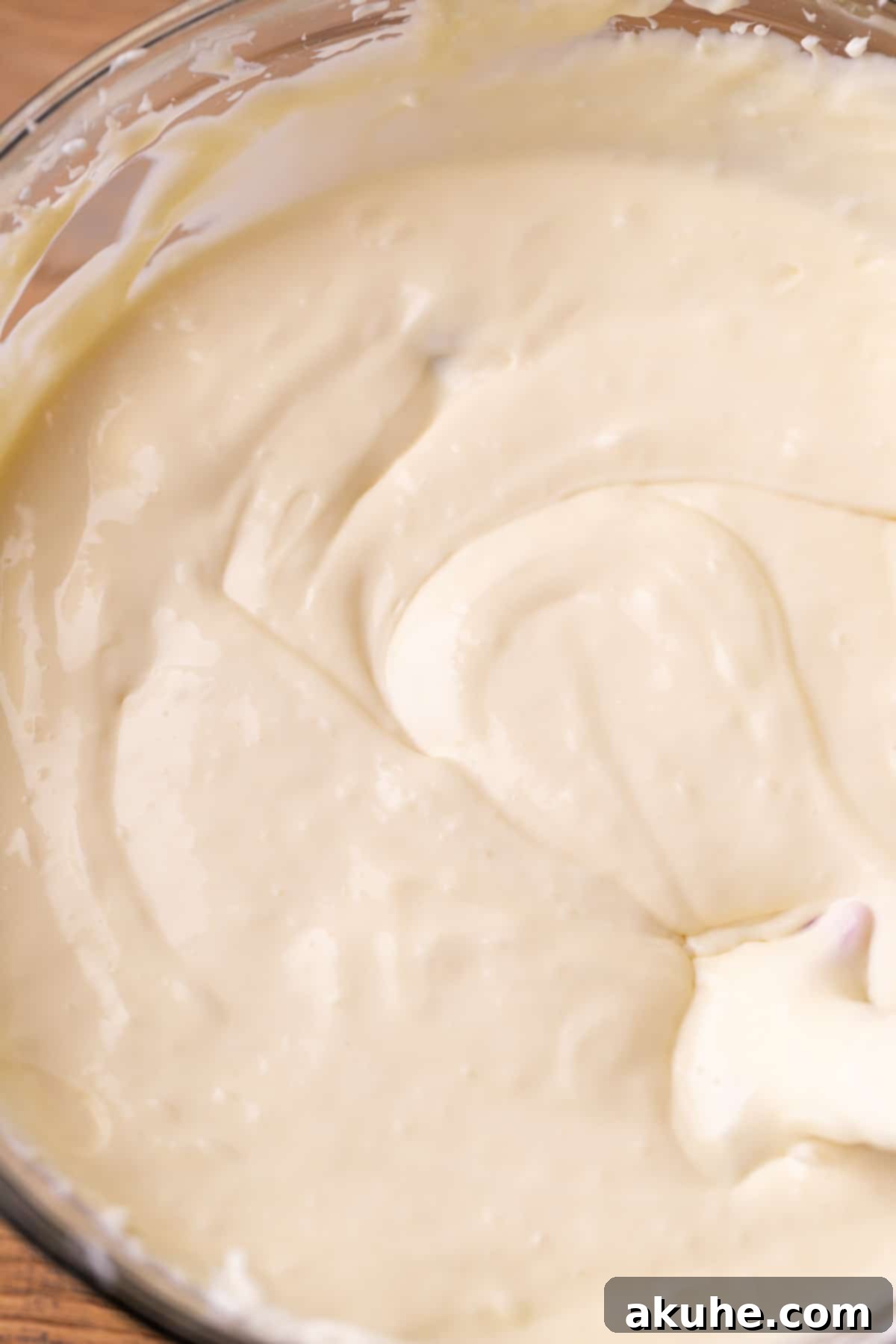 Sugar Cookie Dream Cheesecake 8 Smooth and creamy cheesecake batter in a clear glass bowl, ready for the final touches.
