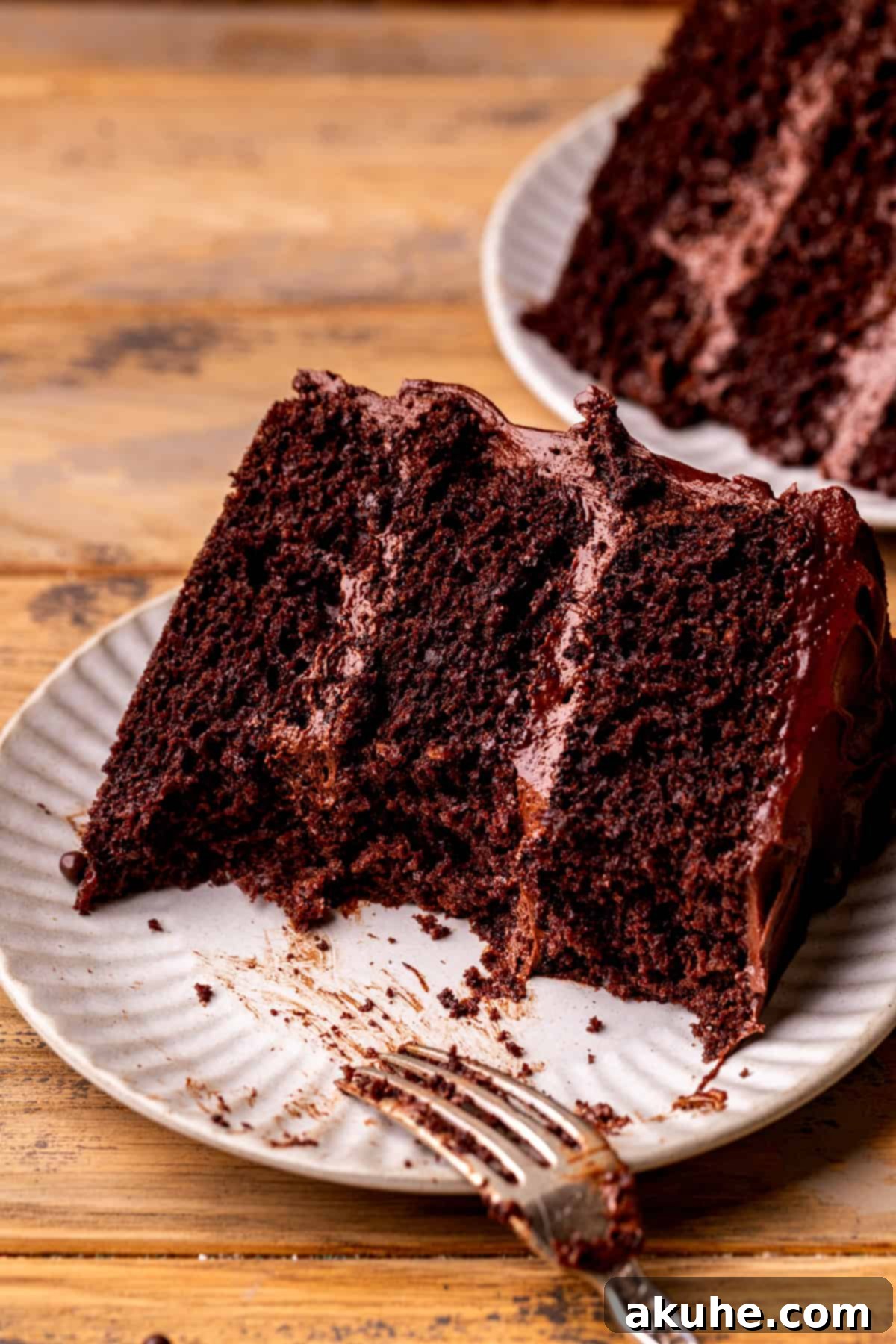 A slice of moist chocolate cake with a few bites taken, revealing its soft texture and creamy frosting.