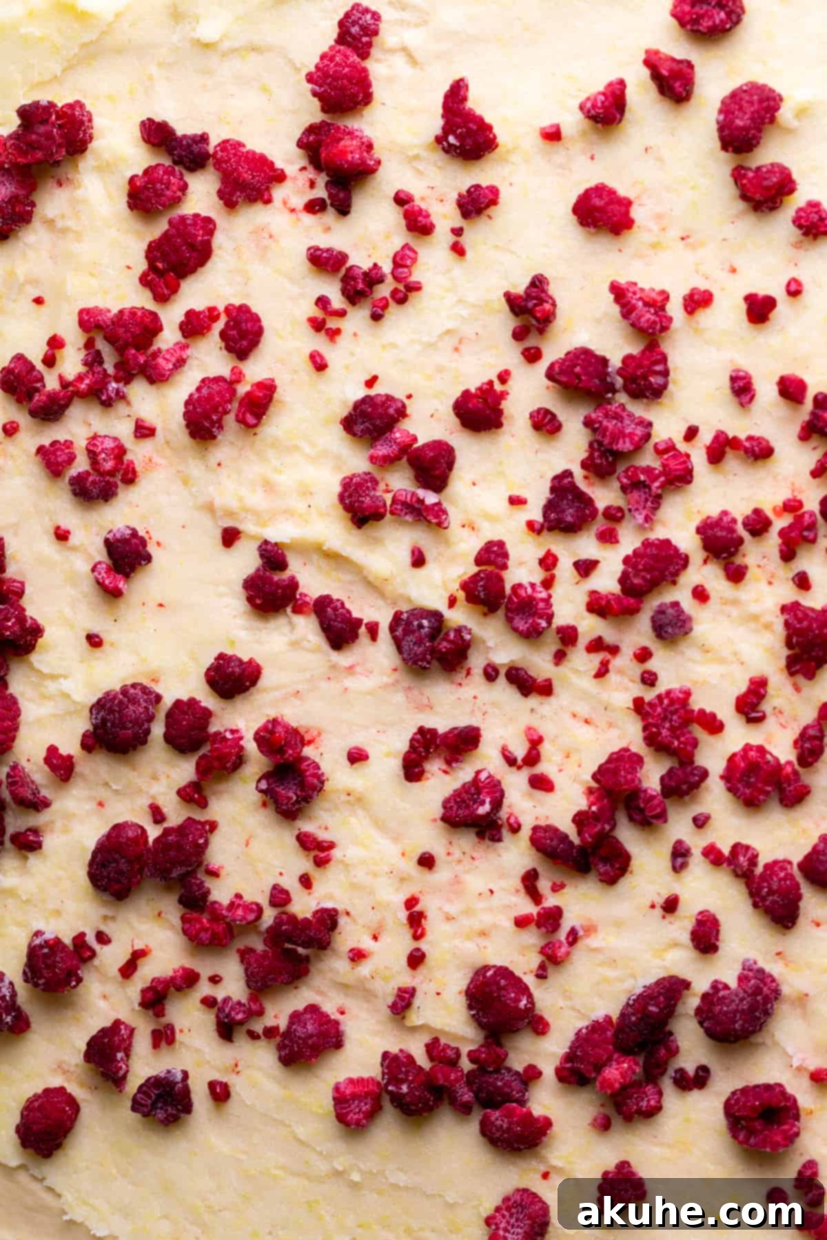 Tangy Lemon Raspberry Buns 4 Fresh raspberries sprinkled over the lemon filling on rolled-out dough, ready to be formed into a log for lemon raspberry rolls.