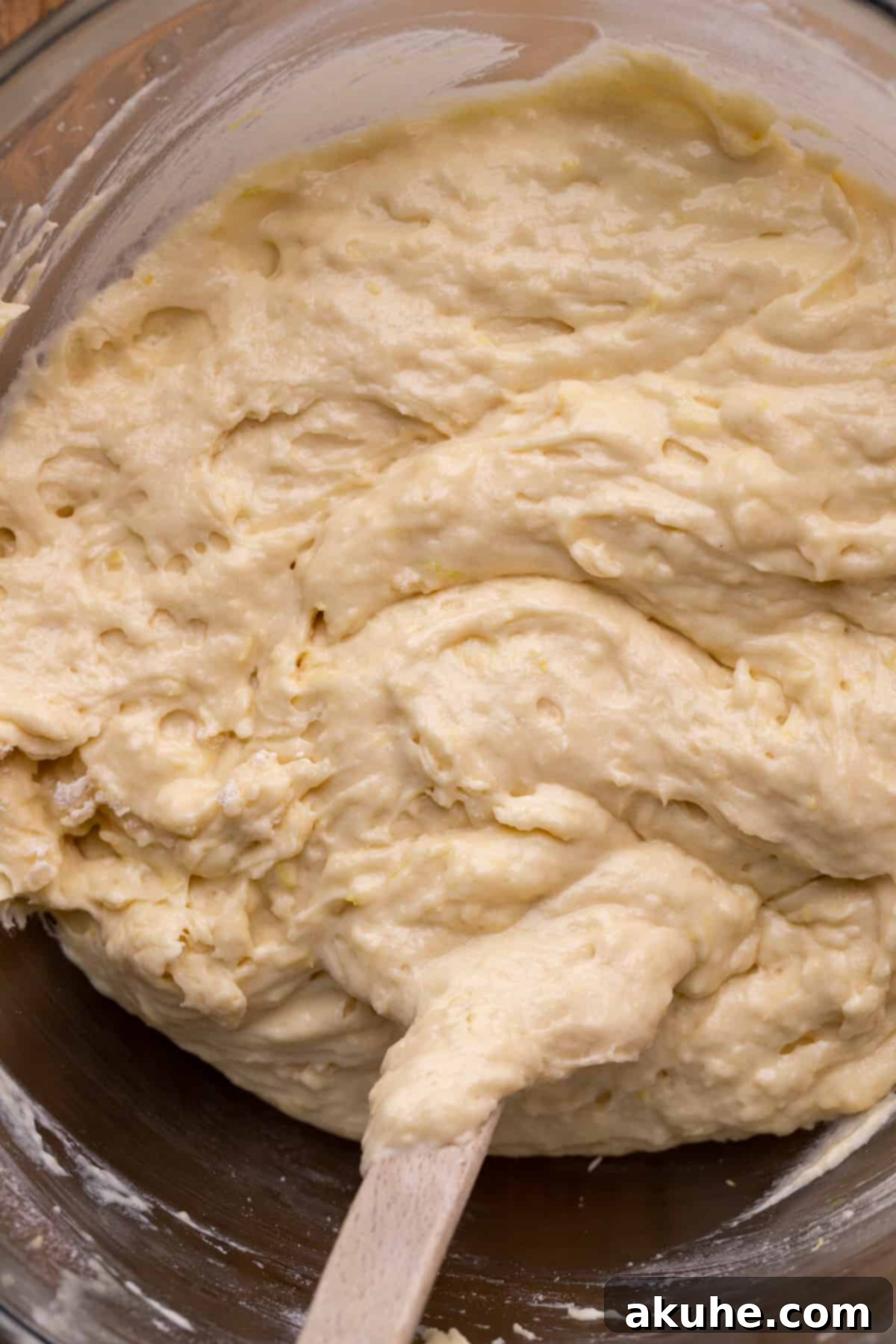 Smooth lemon cake batter ready for baking, captured in a clear glass bowl.