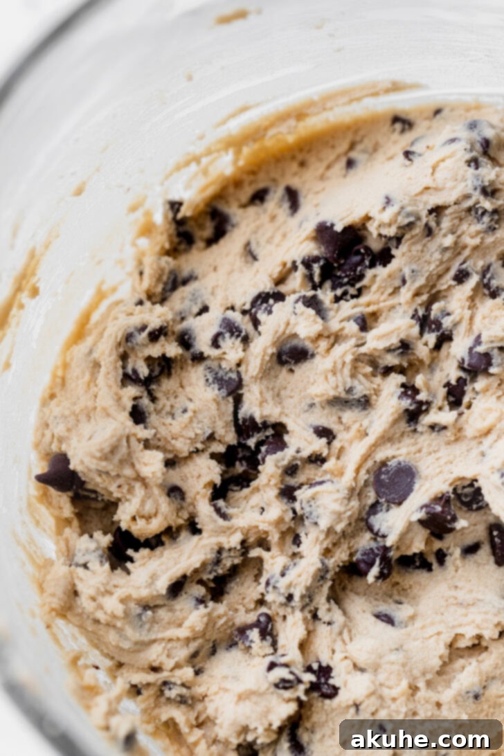 Gooey Caramel Chocolate Chip Cookies 5 Chocolate chip cookie dough with a blend of semi-sweet and mini chocolate chips in a mixing bowl.