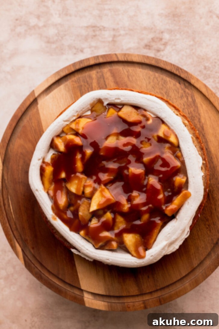Decadent Caramel Apple Delight 9 Cake layer with a piped frosting border, apple pie filling, and caramel drizzle.