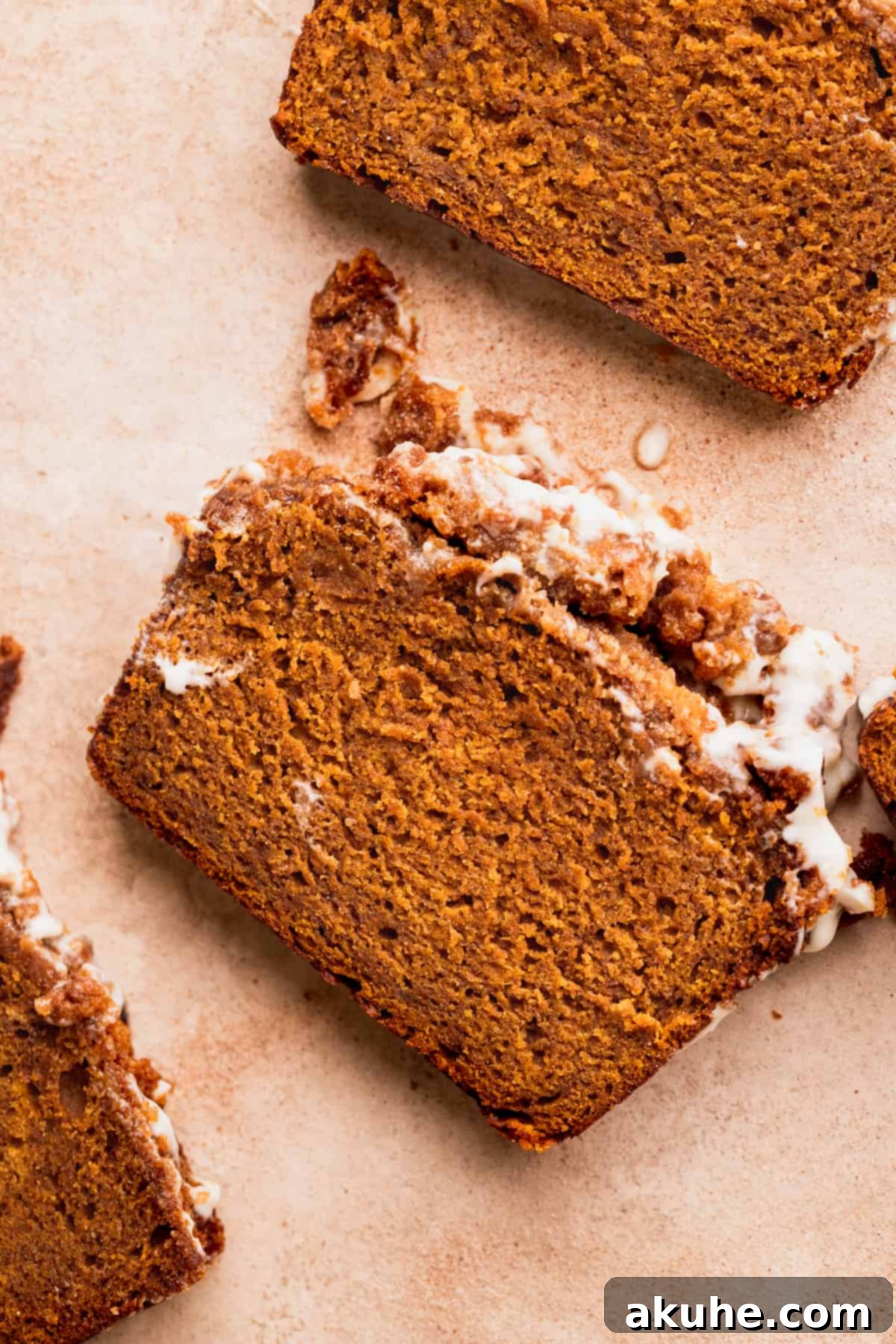 Spiced Pumpkin Loaf with Cream Cheese Frosting 10 A perfectly cut slice of pumpkin bread with cream cheese frosting, ready to be enjoyed.