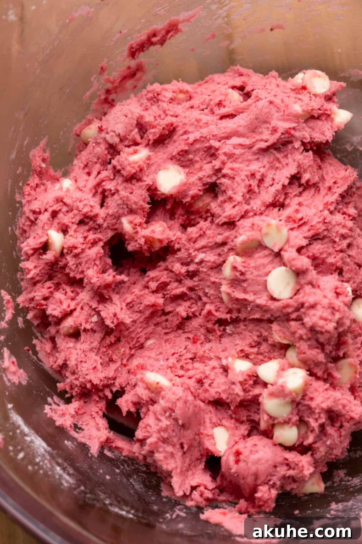 Pink Strawberry Crinkle Delights 5 Cookie dough in a glass bowl, showcasing the combined ingredients with white chocolate chips.