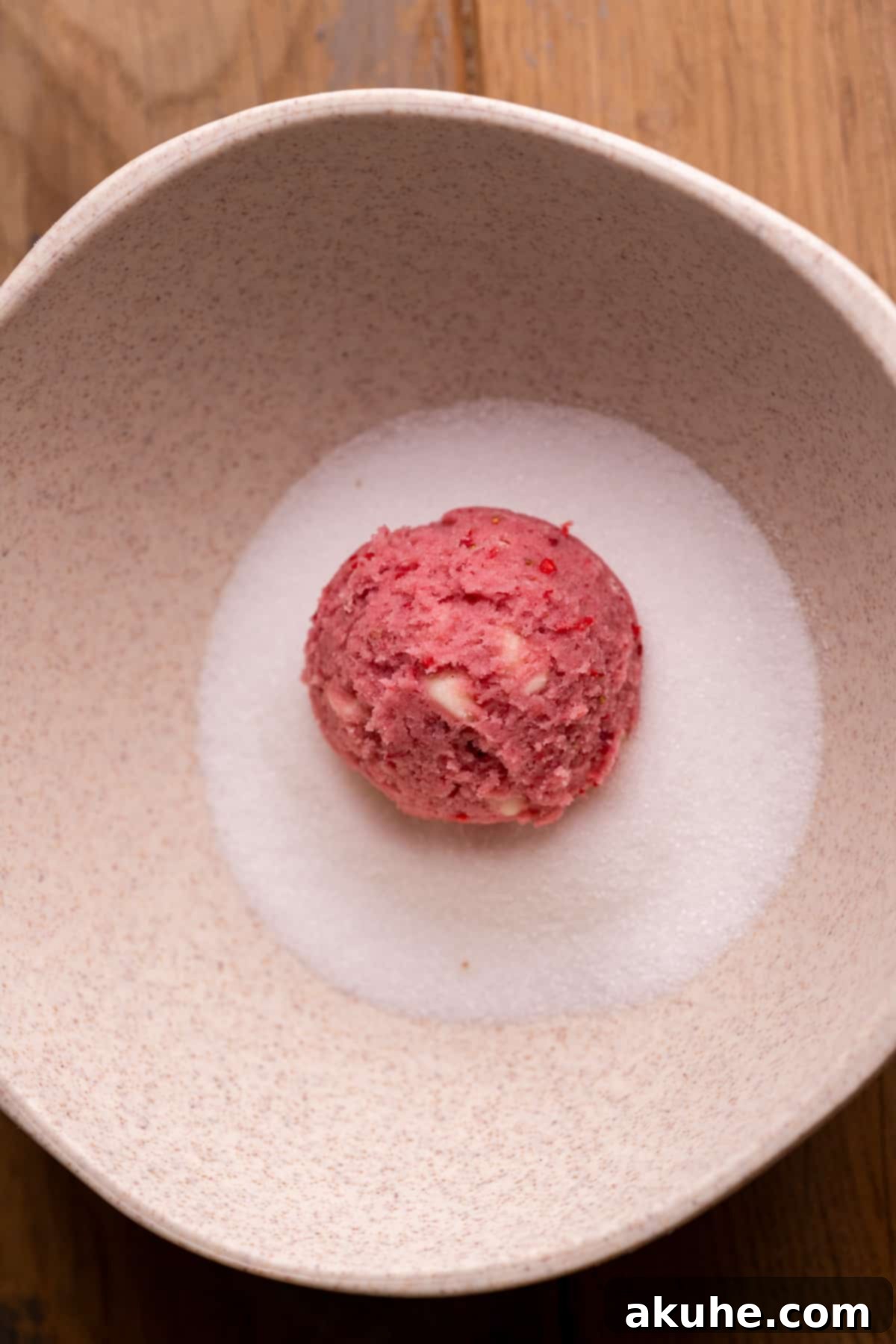 Pink Strawberry Crinkle Delights 6 Cookie dough ball being rolled in granulated sugar.