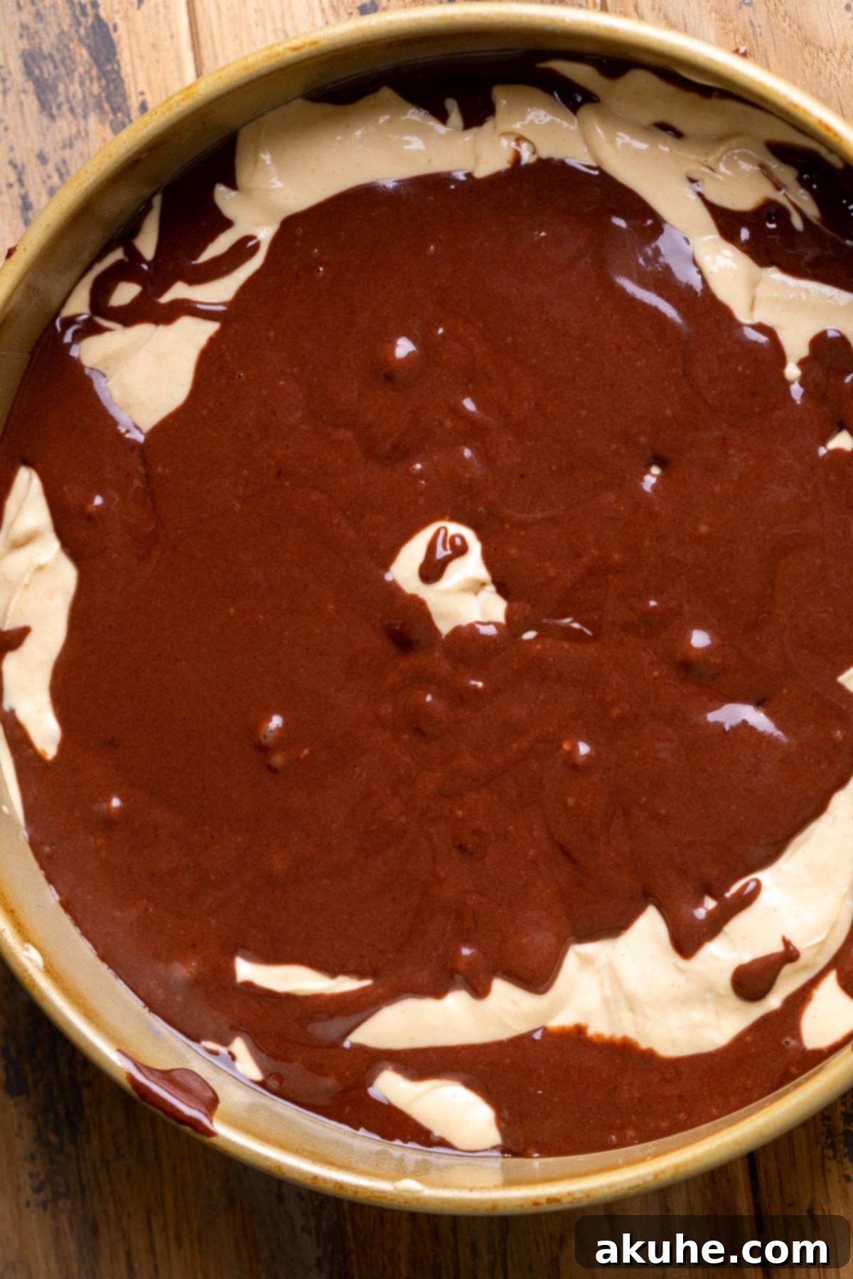 Ultimate Peanut Butter Chocolate Cheesecake 6 The chocolate cake batter and peanut butter cheesecake batter beautifully swirled together in a springform pan, creating an artistic marbled effect.