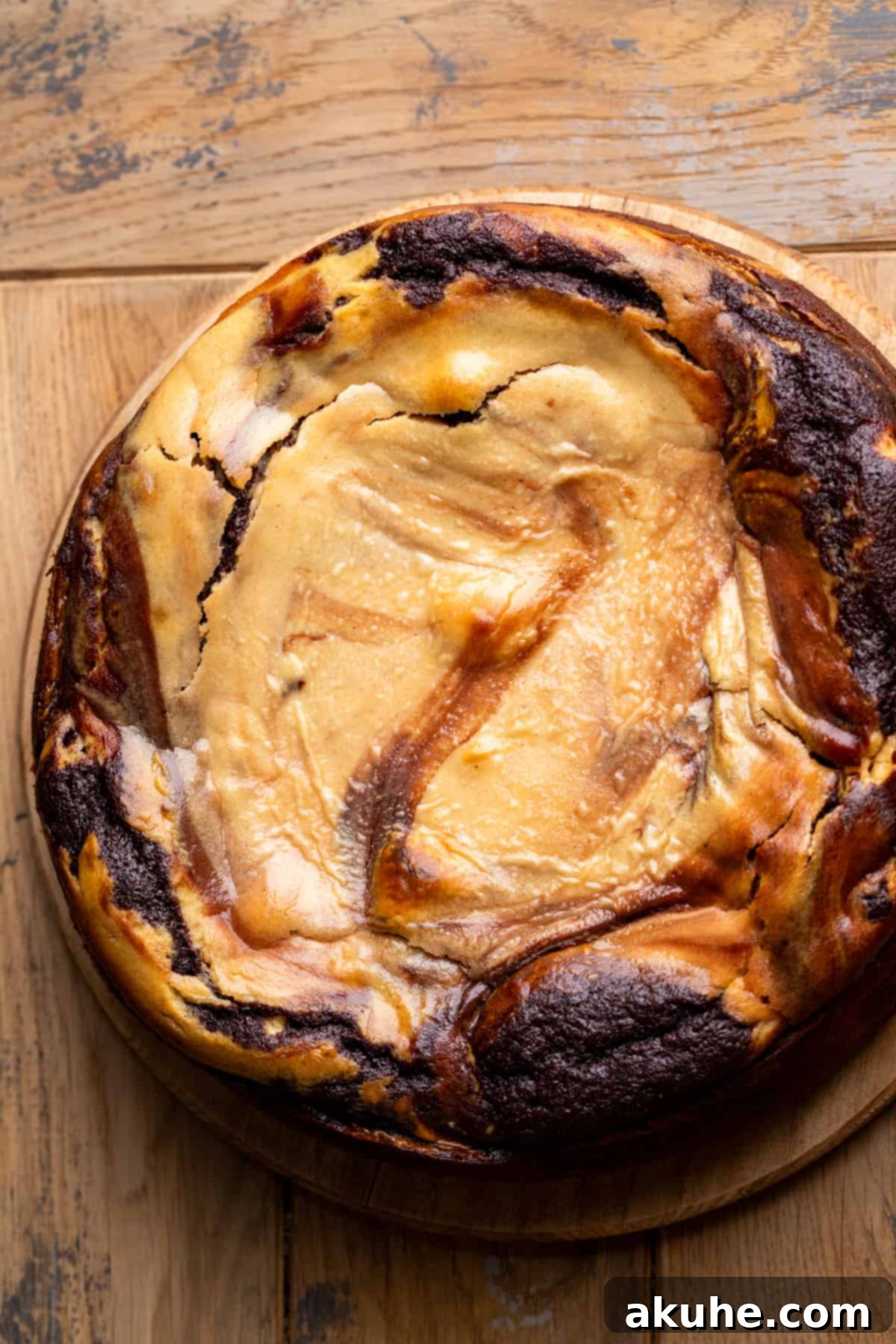 Ultimate Peanut Butter Chocolate Cheesecake 8 A perfectly baked chocolate peanut butter cheesecake, golden-brown and set, resting on a serving platter.
