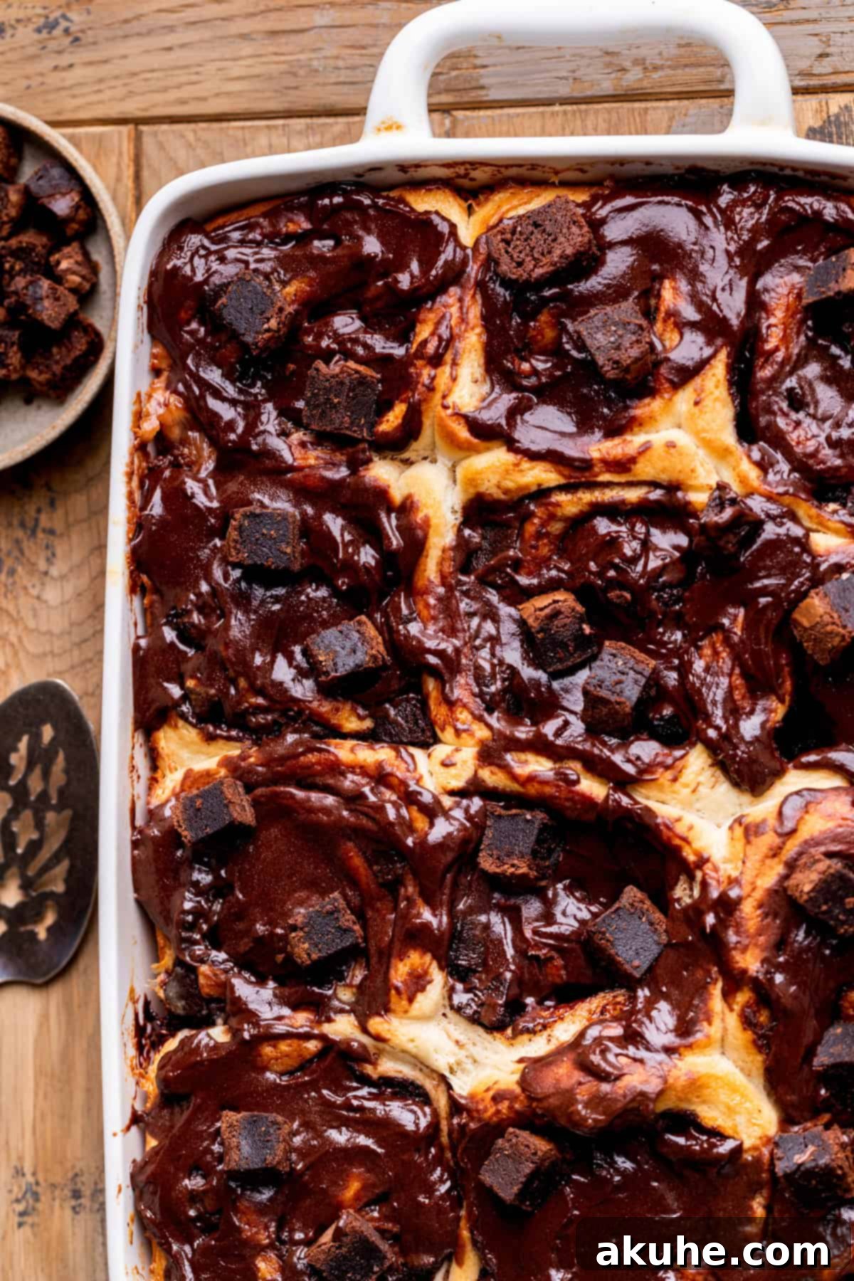Brownie Swirls 8 Top view of beautifully arranged brownie rolls in a baking pan, generously iced.
