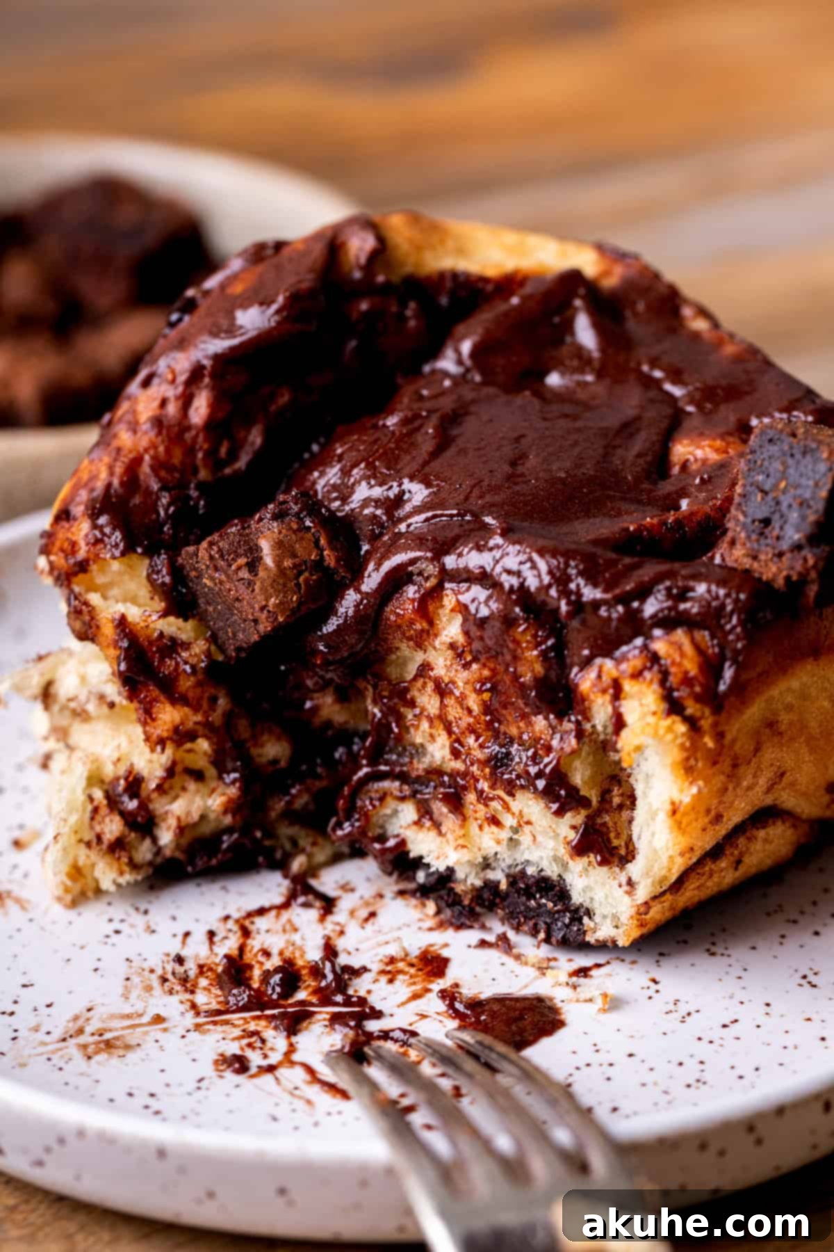 Brownie Swirls 10 A delicious brownie roll on a plate with a bite missing, showing the gooey interior.