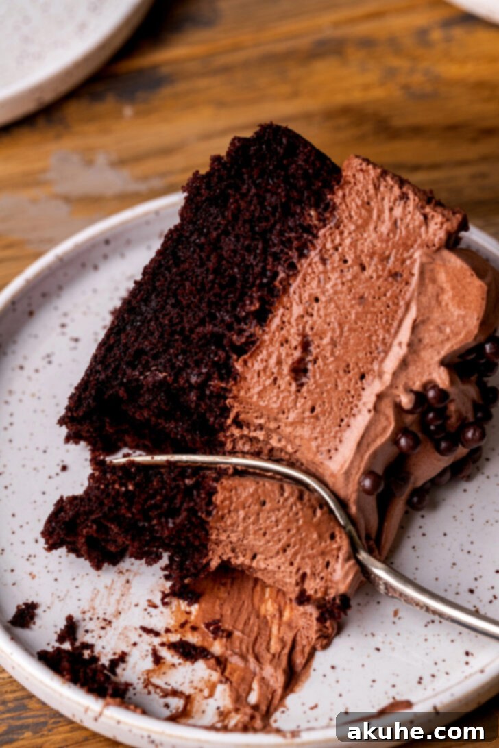 Decadent Chocolate Mousse Dream 12 A fork inserted into a slice of chocolate mousse cake, ready to be eaten.