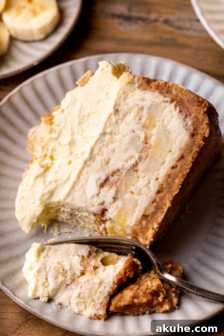 Southern Banana Pudding Cheesecake 12 One slice of banana pudding cheesecake on a plate with a bite taken out, showing the creamy texture.