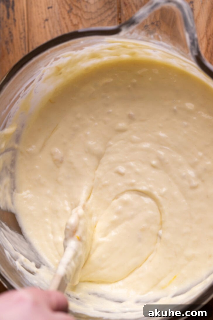 Southern Banana Pudding Cheesecake 5 Banana cheesecake batter in a mixing bowl, showing a slightly lumpy texture due to mashed bananas.