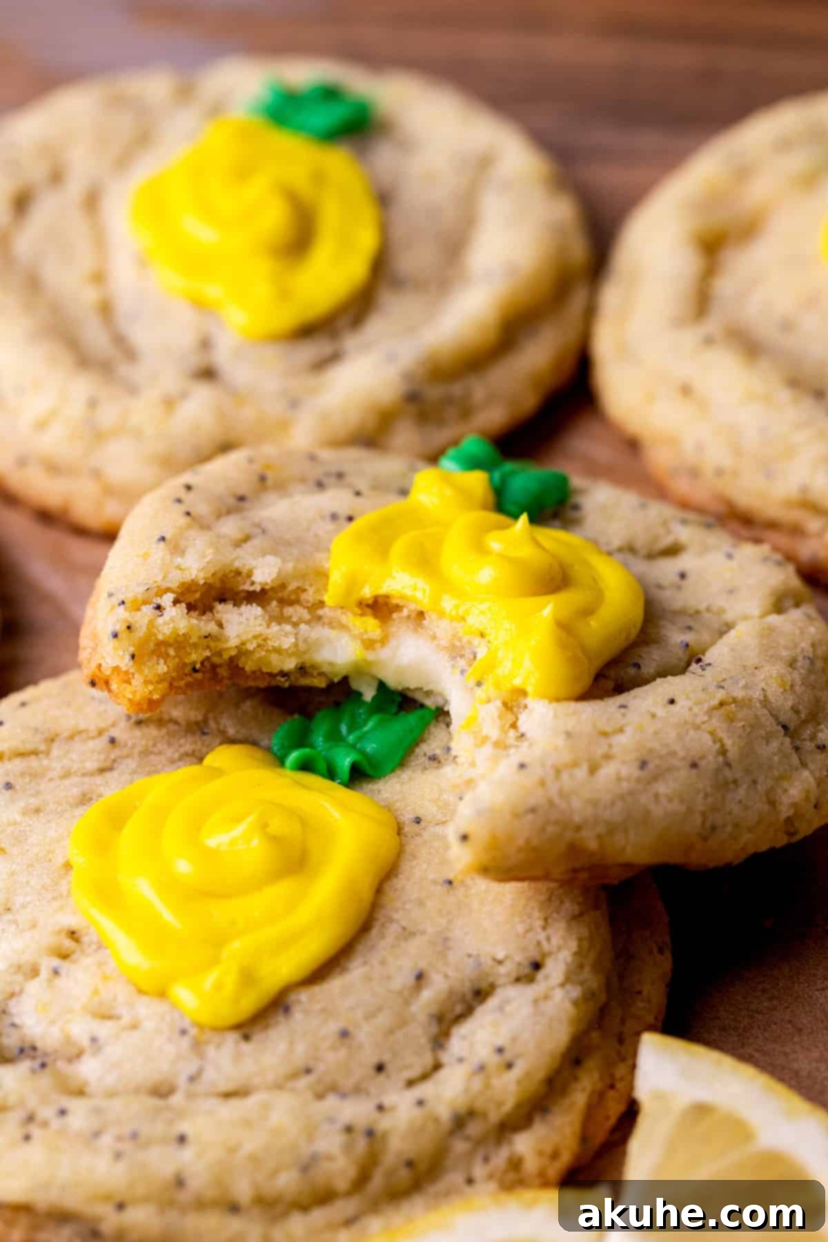Zesty Lemon Poppy Seed Cookies 2 A bite missing from a lemon poppy seed cookie, revealing the creamy cheesecake filling.