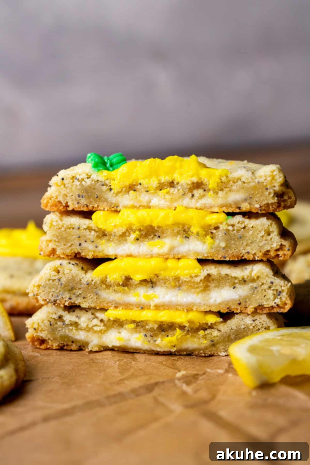 Zesty Lemon Poppy Seed Cookies 3 Two lemon poppy seed cookies split in half stacked on top of each other, showcasing the cheesecake center.