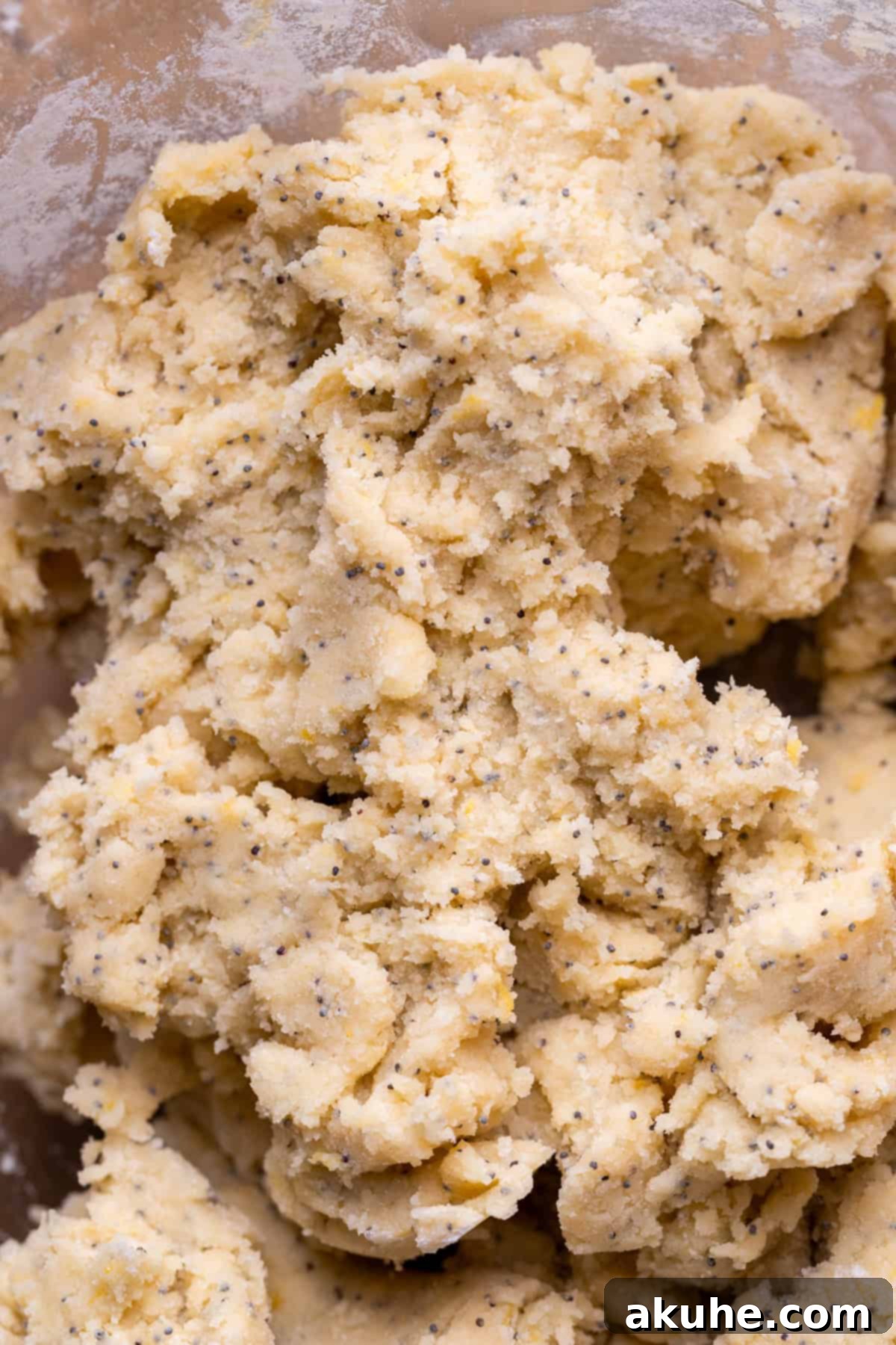 Zesty Lemon Poppy Seed Cookies 6 Thick lemon cookie dough in a glass bowl, prepared for filling.