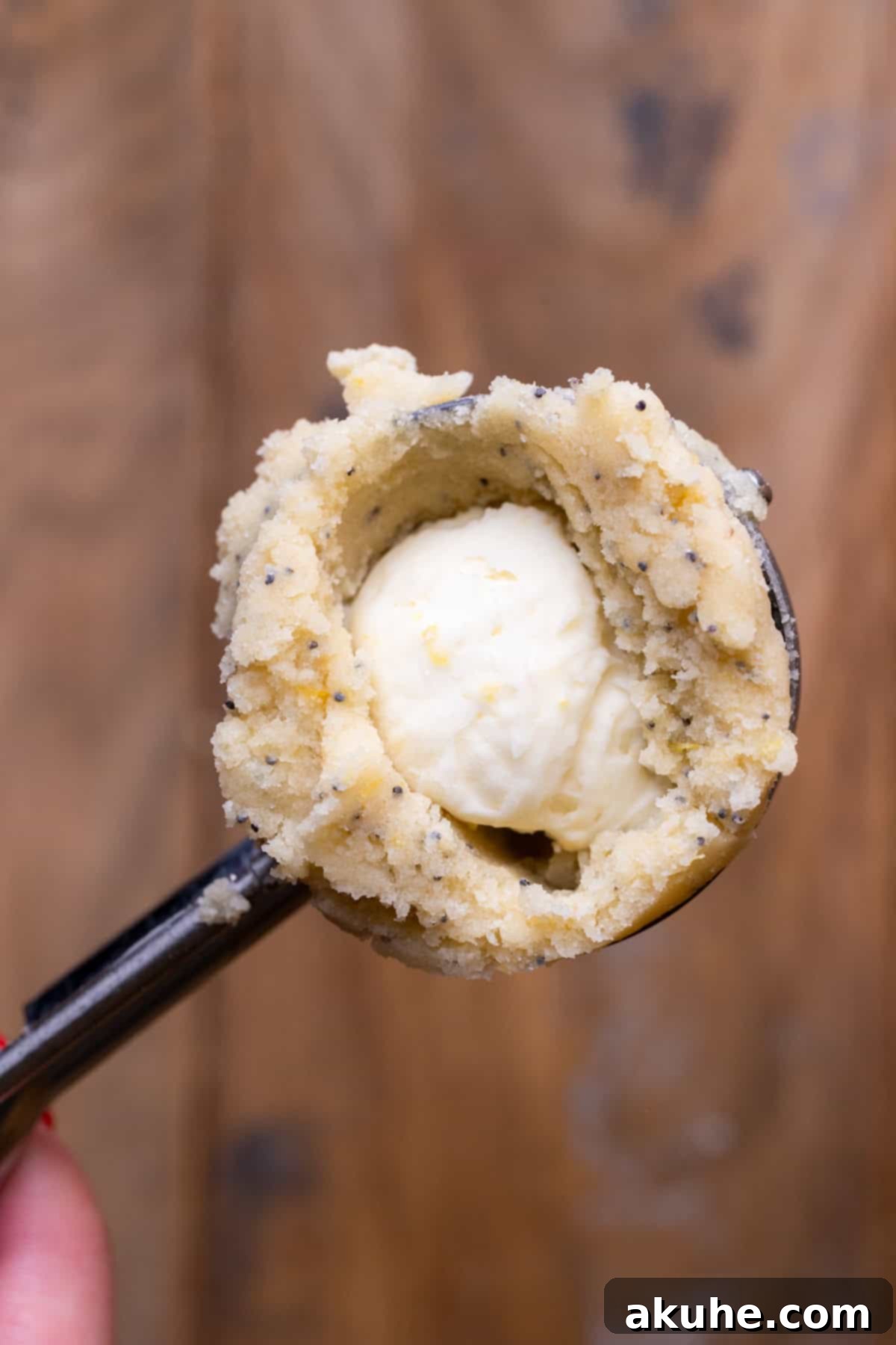 Zesty Lemon Poppy Seed Cookies 7 Cookie dough in a scoop with a cheesecake dollop pressed into the middle.