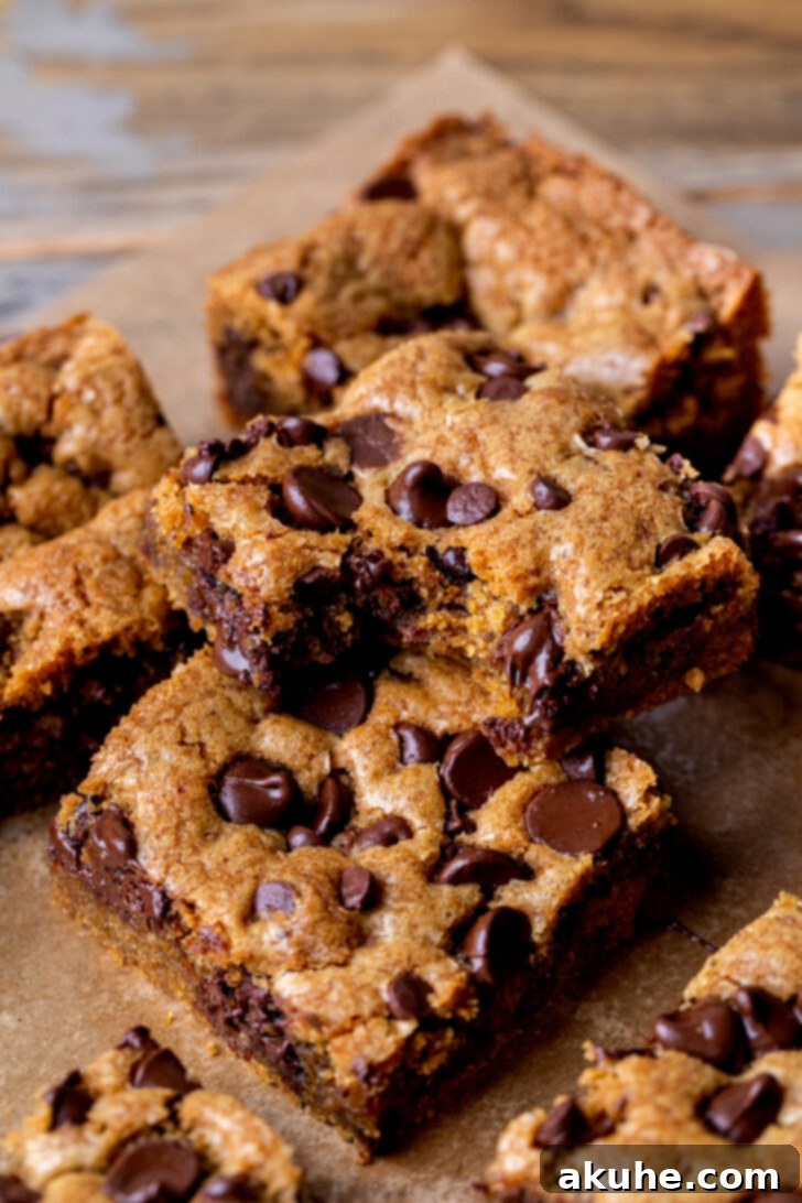 Nutty Brown Butter Chocolate Chip Cookie Slices 3 A stack of two perfectly baked brown butter chocolate chip cookie bars, with one showing a bite removed to reveal its soft, chewy interior filled with melted chocolate.