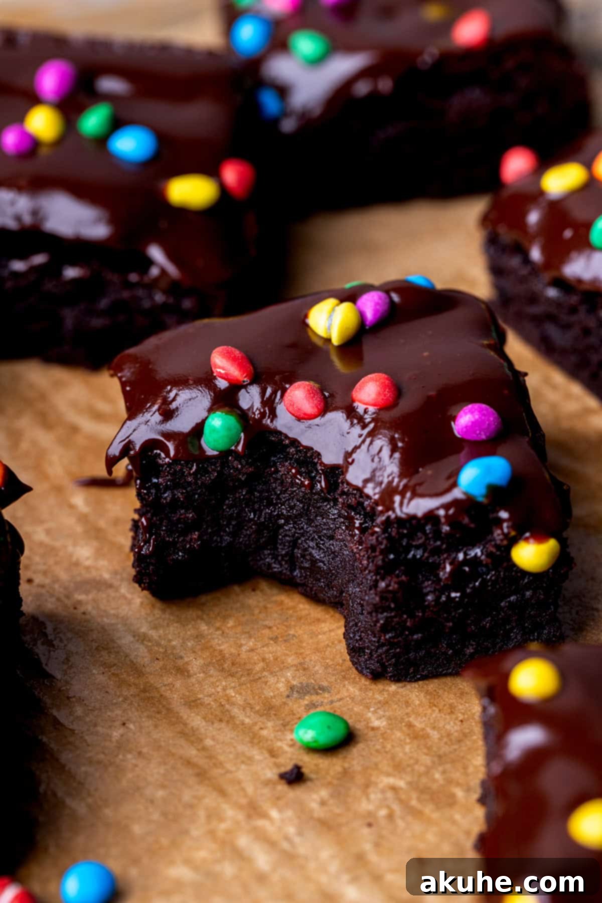 Decadent Cosmic Brownies 2 A perfectly baked, fudgy homemade Cosmic Brownie with a bite taken out, showing its rich texture and colorful candy topping.